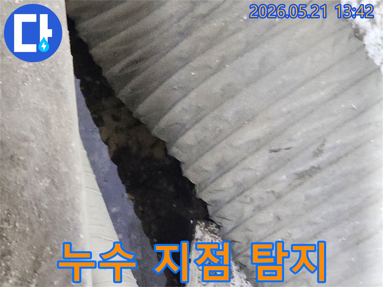 누수-현장에서-정확한-누수-지점을-탐지하고-조치를-취하기-위해-배관-주변을-살피는-모습
