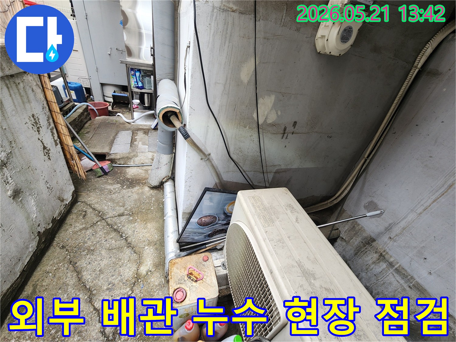 야외에 설치된 배관에서-누수가 발생하여-전문가가 점검하는 모습입니다