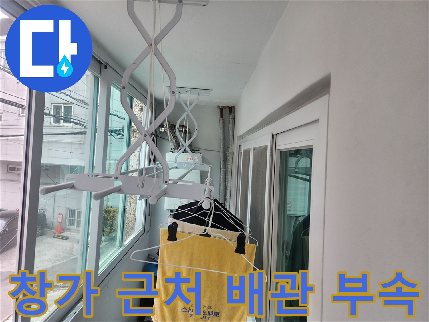 창문 외부로 노출된 하얀색 배관 지지대와 주변 벽면입니다.