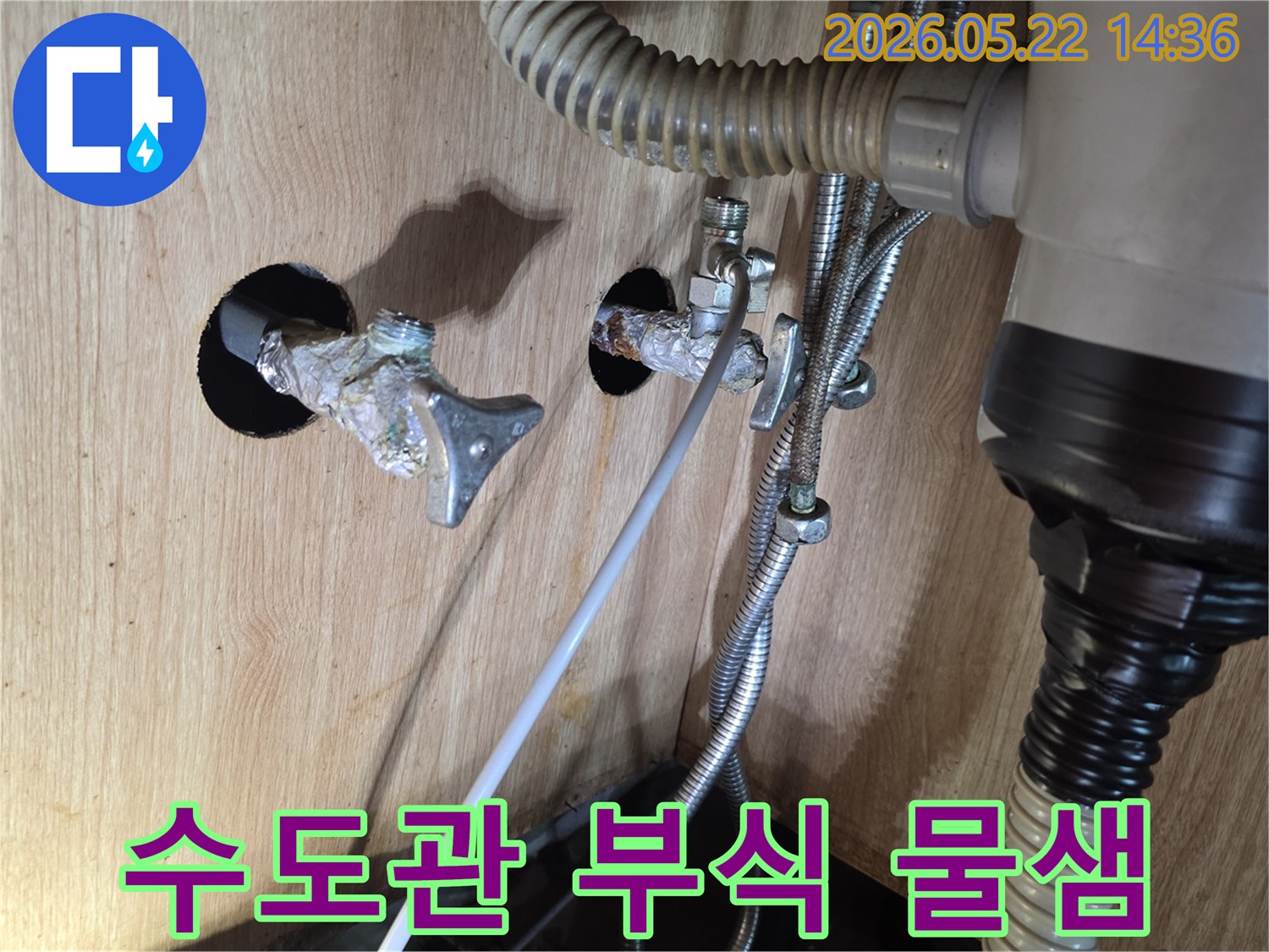 싱크대 하부의 수도관이 부식되어 물이 새고 있는 심각한 상태를 보여주는 사진입니다