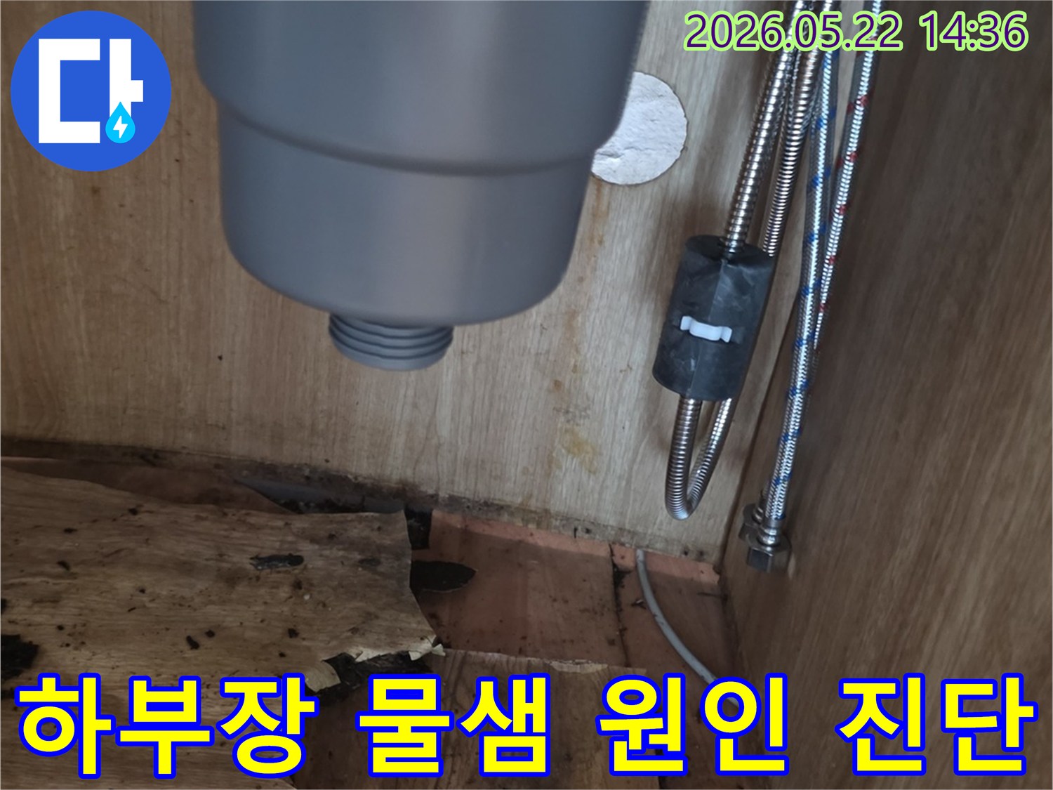 싱크대 하부장 내부의 물샘 흔적과-손상된 목재-그리고 배관의 모습을-전문가가 정밀하게 진단하는 현장 사진