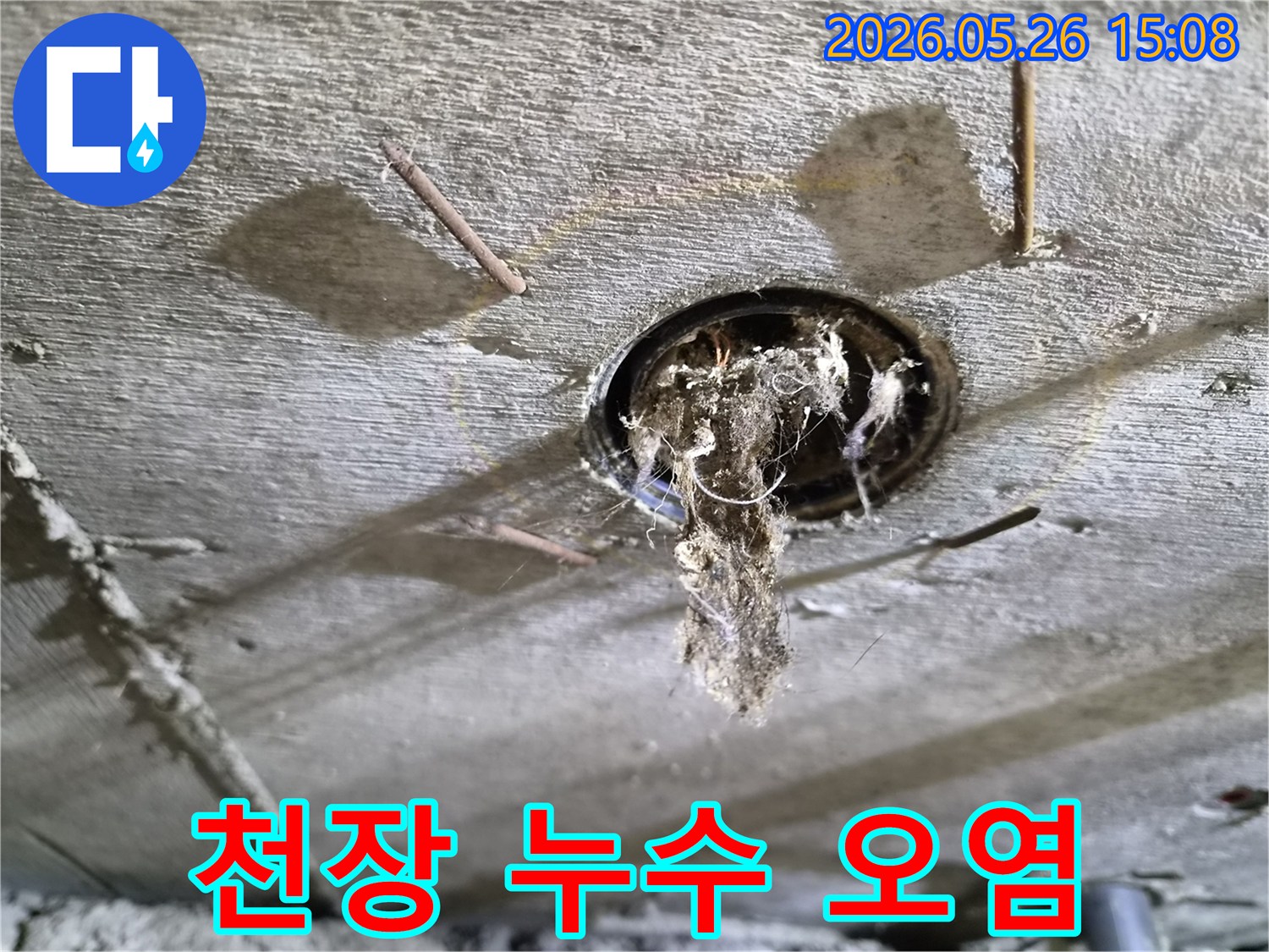콘크리트 천장 구멍에서-심각하게-오염된-이물질이-떨어지는-누수-현장의-모습을-보여주는-사진