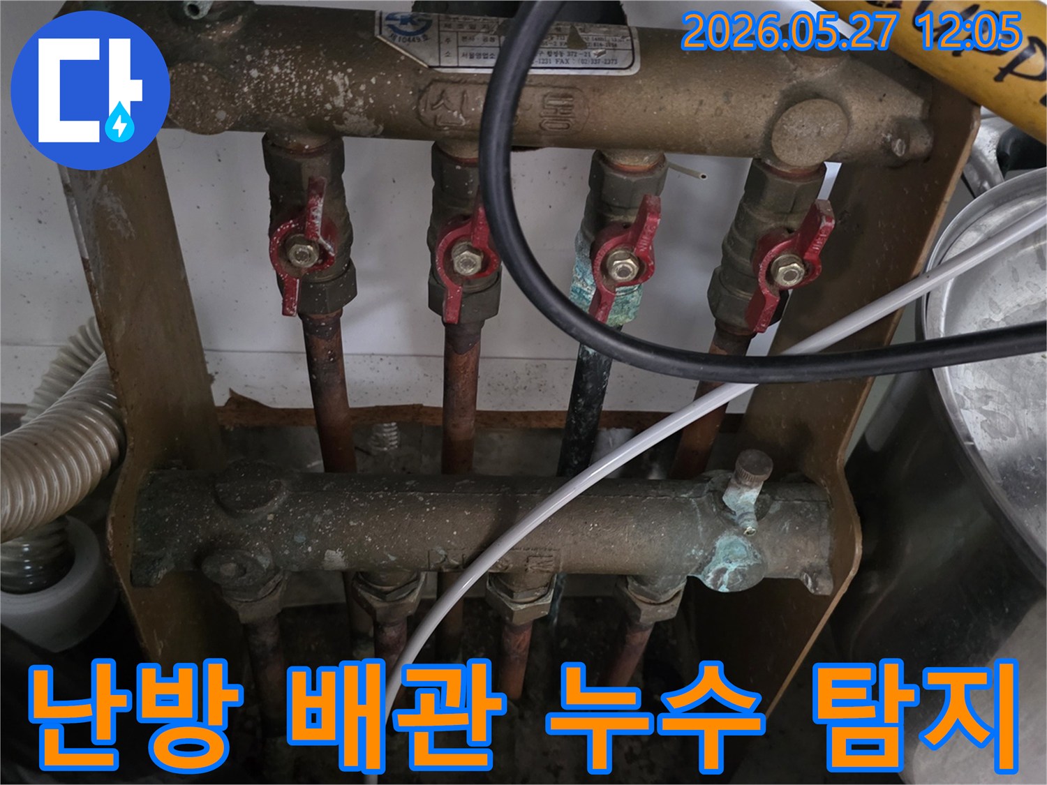 오래된 아파트의 난방 분배기 주변에서-발생한 배관 누수를-전문가가 정밀하게 탐지하고 있습니다