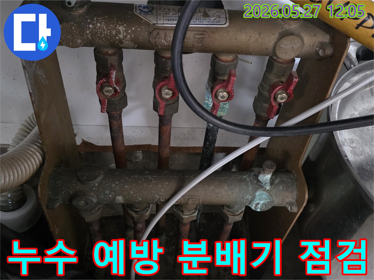 오래된 아파트의 보일러 분배기에서-누수 예방을 위해-전문가가 배관과 밸브의 상태를-정기적으로 점검하고 있는 모습입니다