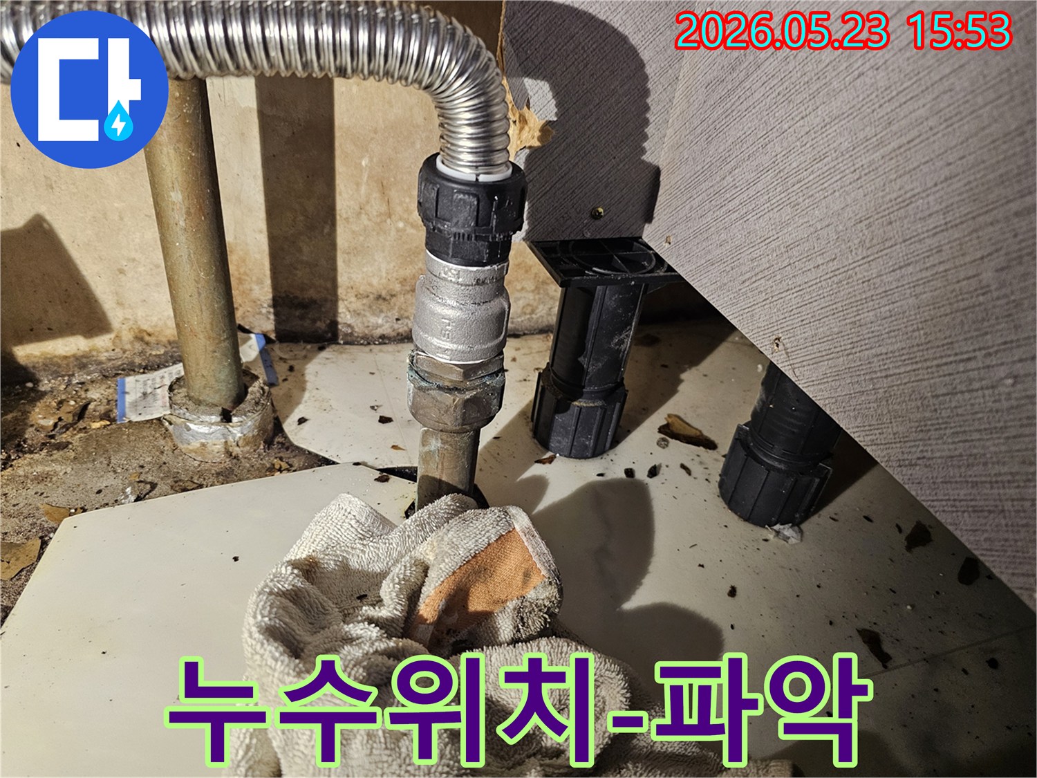 배관 연결부에서 물이 새어-바닥에 젖은 수건이 놓인-누수 위치 파악 현장