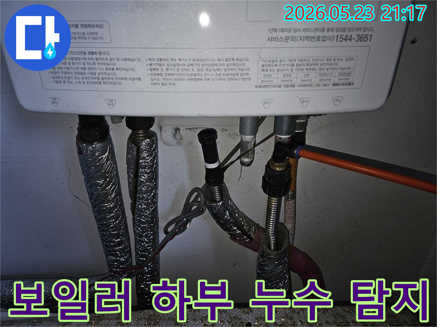 다양한 배관들이 연결된 보일러 하단에서-미세한 누수 지점을 찾아내기 위한-전문가의 시선입니다