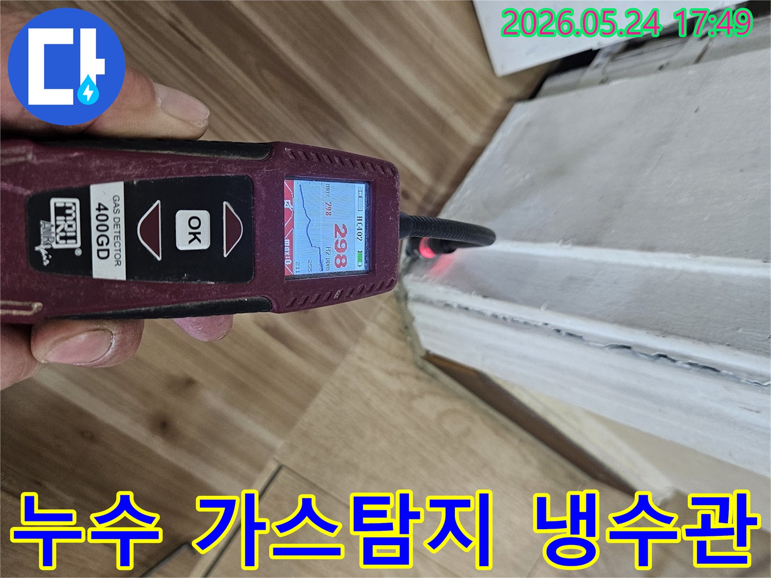 누수 엔지니어가 가스 탐지기를 사용하여 벽면과 바닥 경계에서 누수 반응을 정밀하게 확인하고 있습니다.