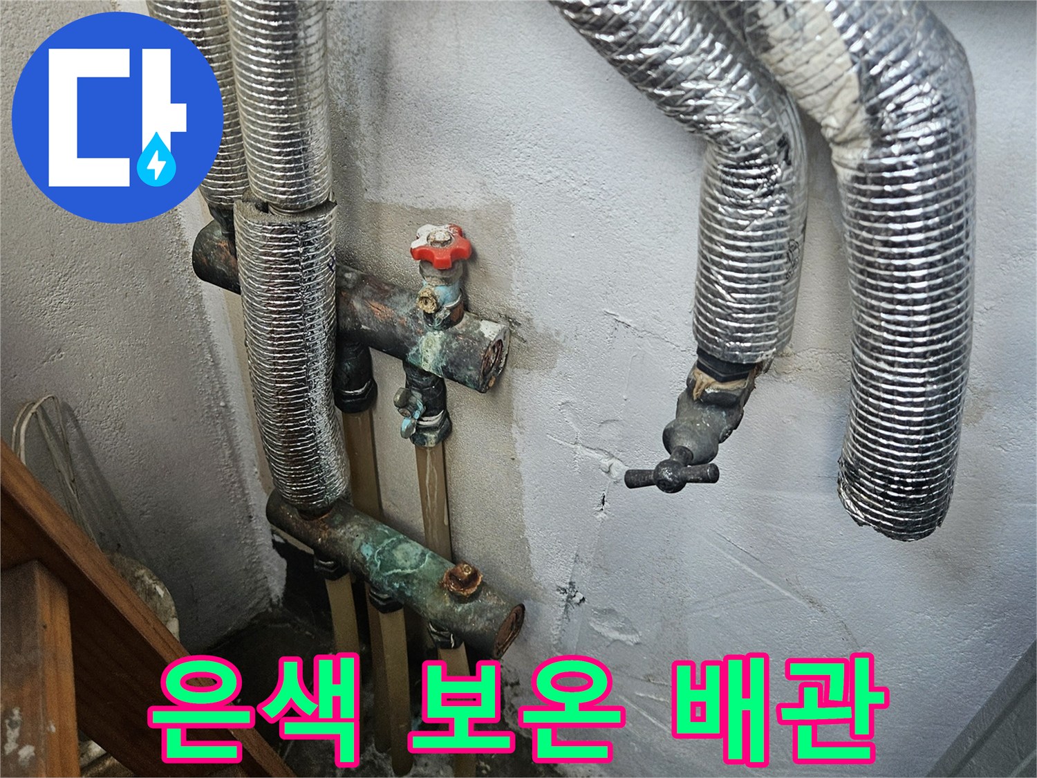 벽면에 설치된 은색 보온재로 감싸진 여러 개의 배관