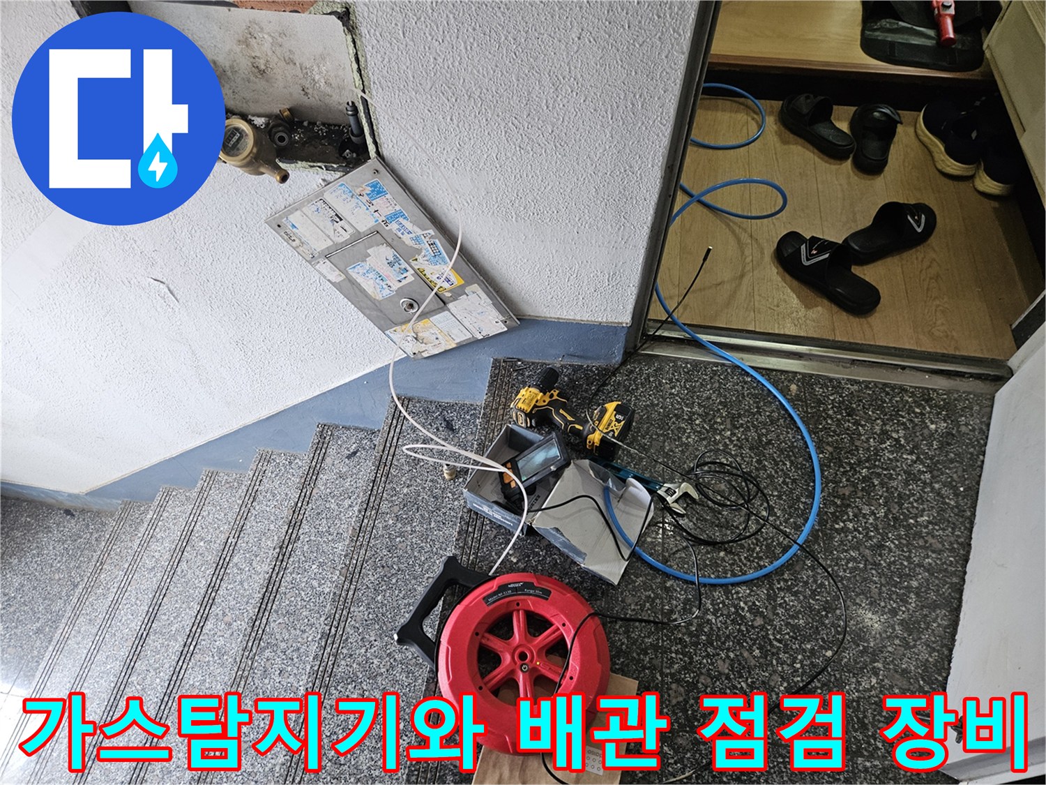 현관 복도 바닥에 놓인 가스 탐지 장비와 검사용 호스 - 누수 지점을 찾기 위한 정밀 진단 과정입니다.
