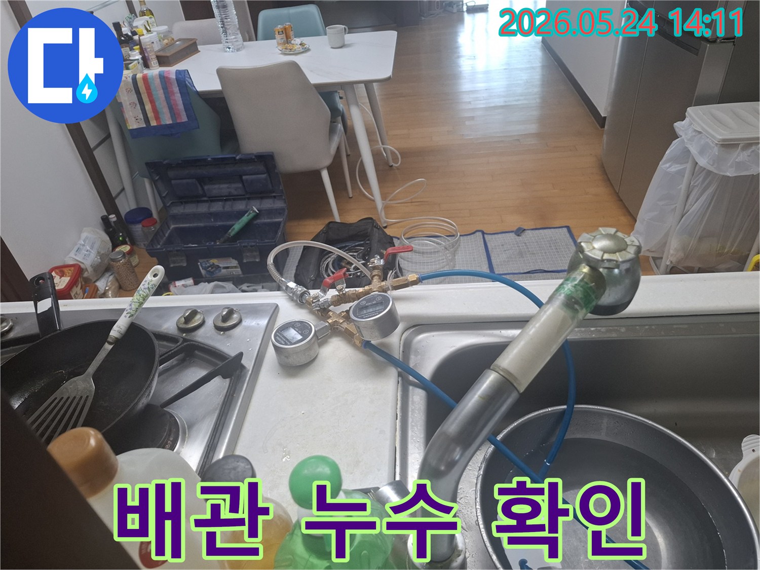 수도 배관의 미세한 누수까지 감지하기 위해-싱크대 수도에-특수 장비를-연결하여-검사하는-장면입니다