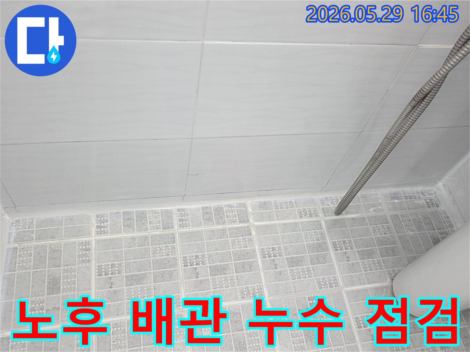 욕실-타일-아래에-위치한-노후-배관의-누수-가능성을-염두에-두고-현장을-점검하는-모습