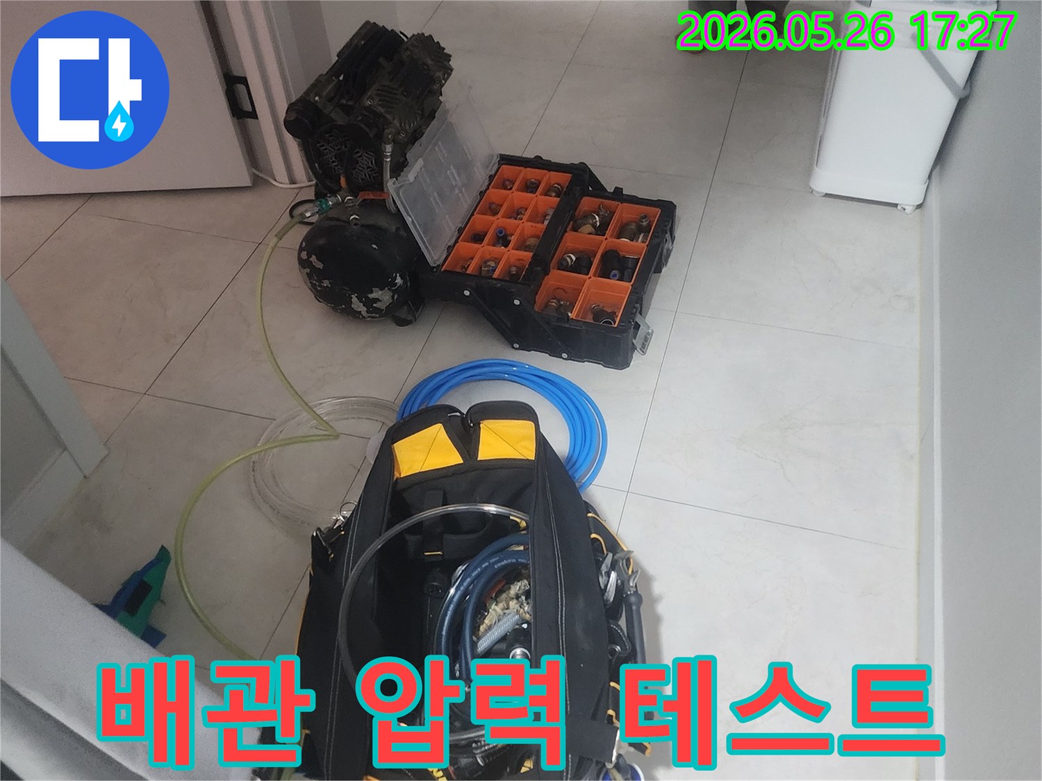 전문가가 누수 지점을 정확히 찾기 위해 고압 검사 장비를 세팅하고 있습니다.