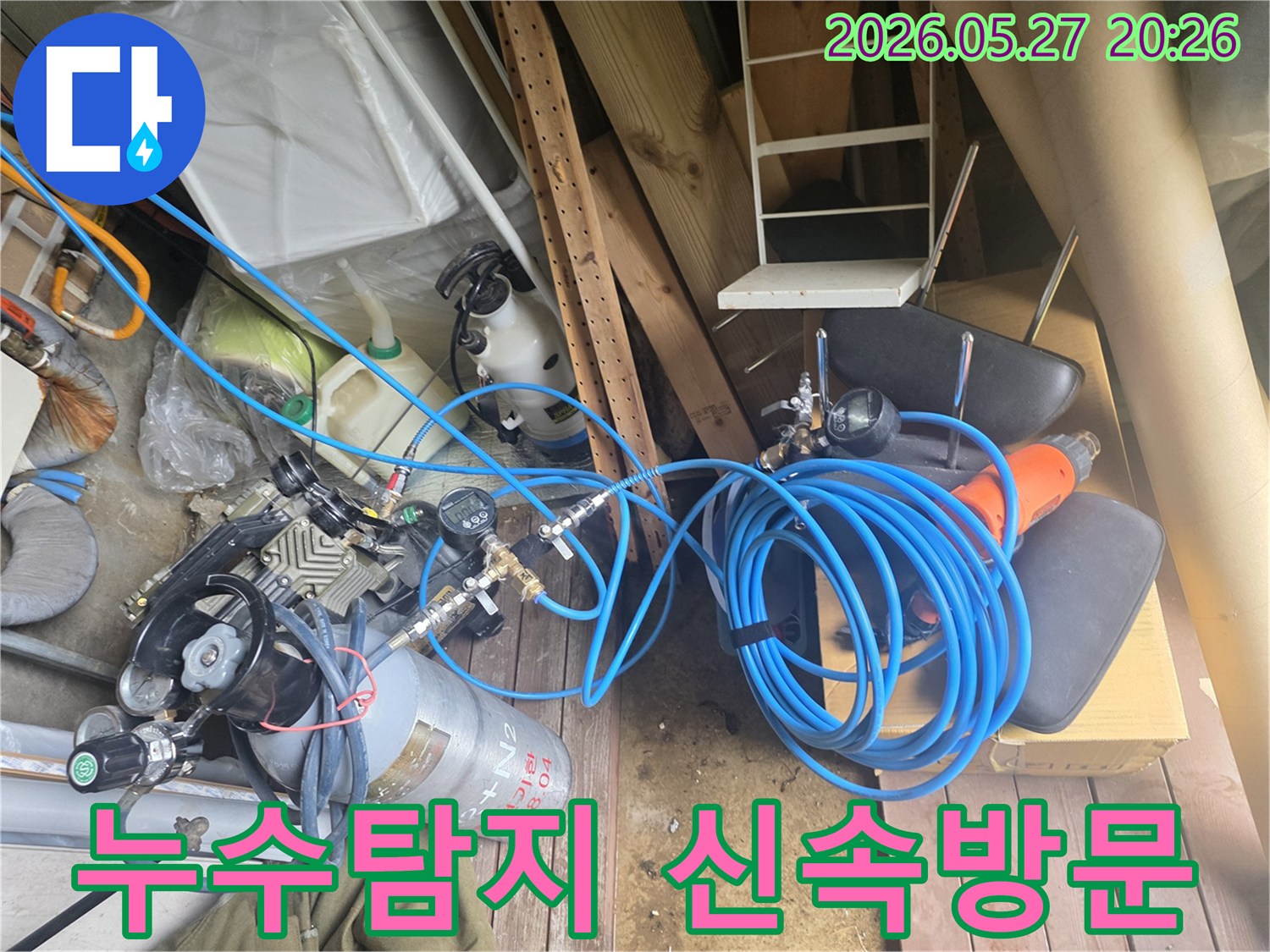 누수 탐지 전문가의 신속한 방문을 위해 준비된 압력 측정 장비와 가스 실린더-그리고 연결된 호스들이 현장에 배치된 모습입니다.