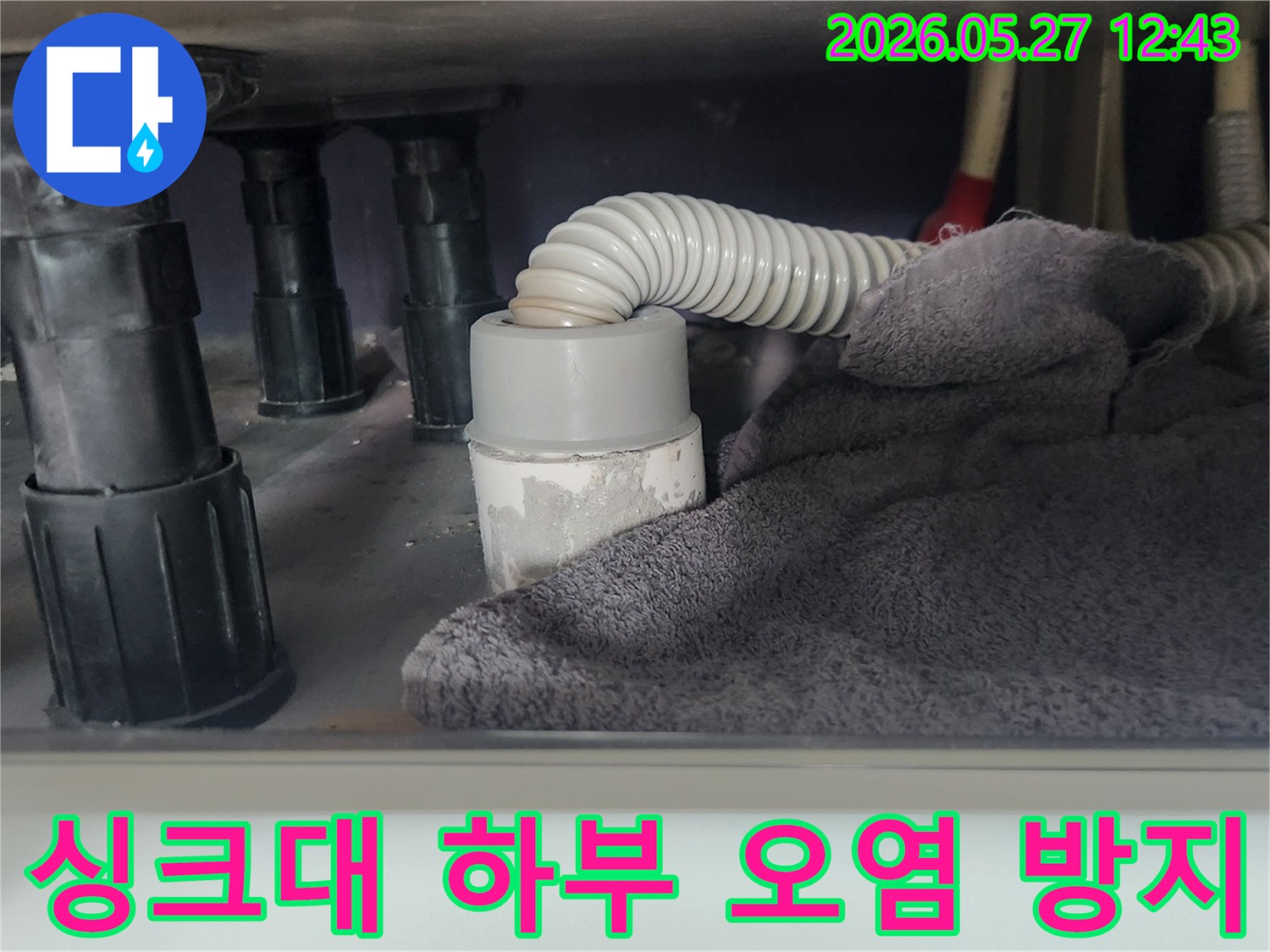 싱크대 배관 작업 전-하부 공간을 보호하고-이물질 유입을 차단하기 위해-수건을 놓아둔 모습입니다