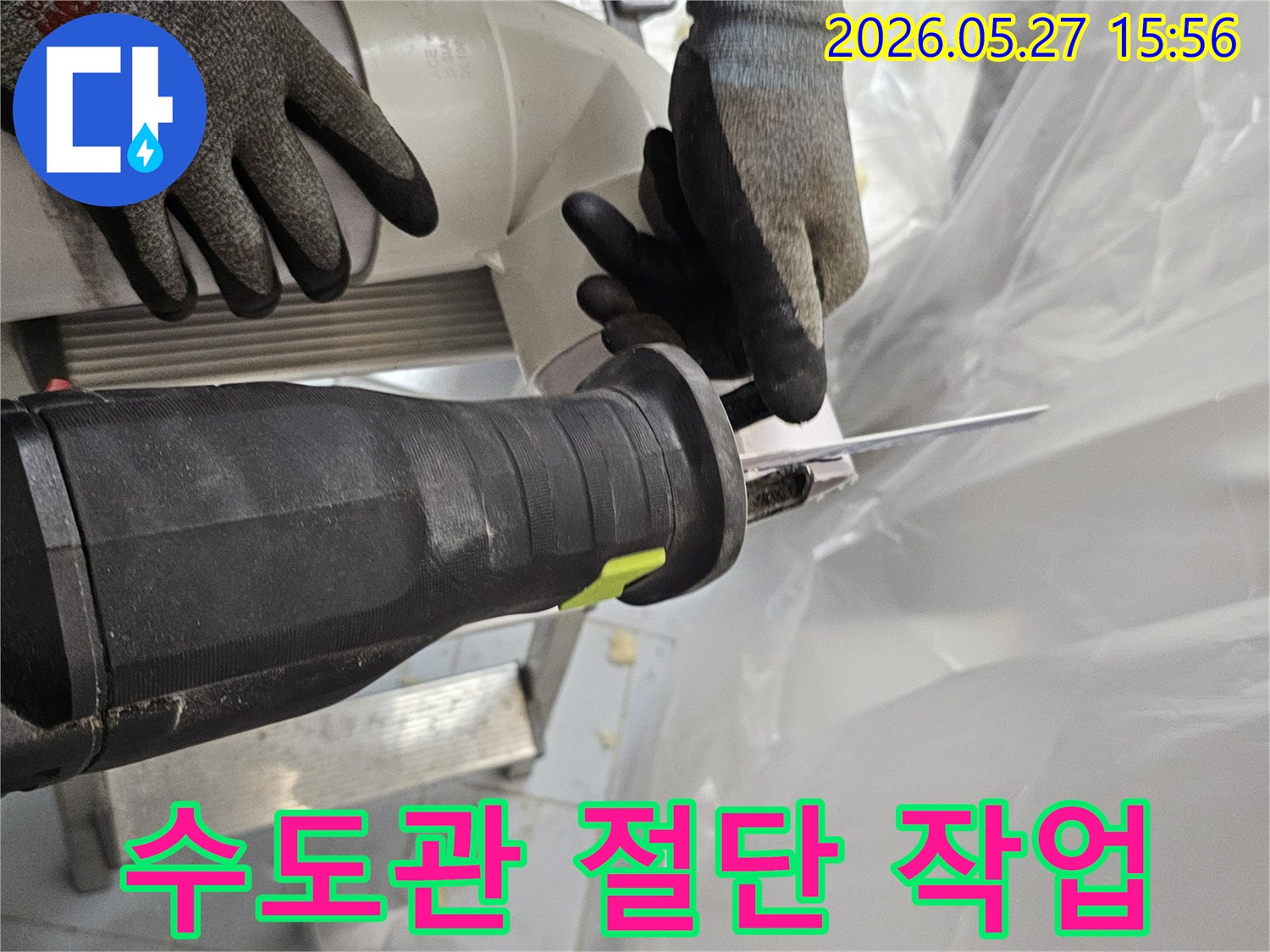 전문-작업자가-안전장갑을-착용하고-전기톱으로-수도관-PVC-파이프를-정밀하게-절단하고-있습니다