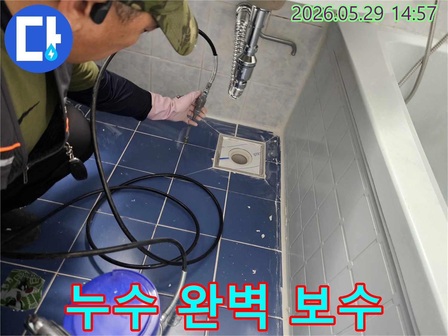 누수 전문 엔지니어가 욕실 바닥 배수구에 특수 장비를 삽입하여 배관 내부를 정밀하게 점검하며 누수 지점을 찾아 완벽 보수를 준비하는 모습입니다-정확한 진단으로 완벽한 수리를 약속합니다