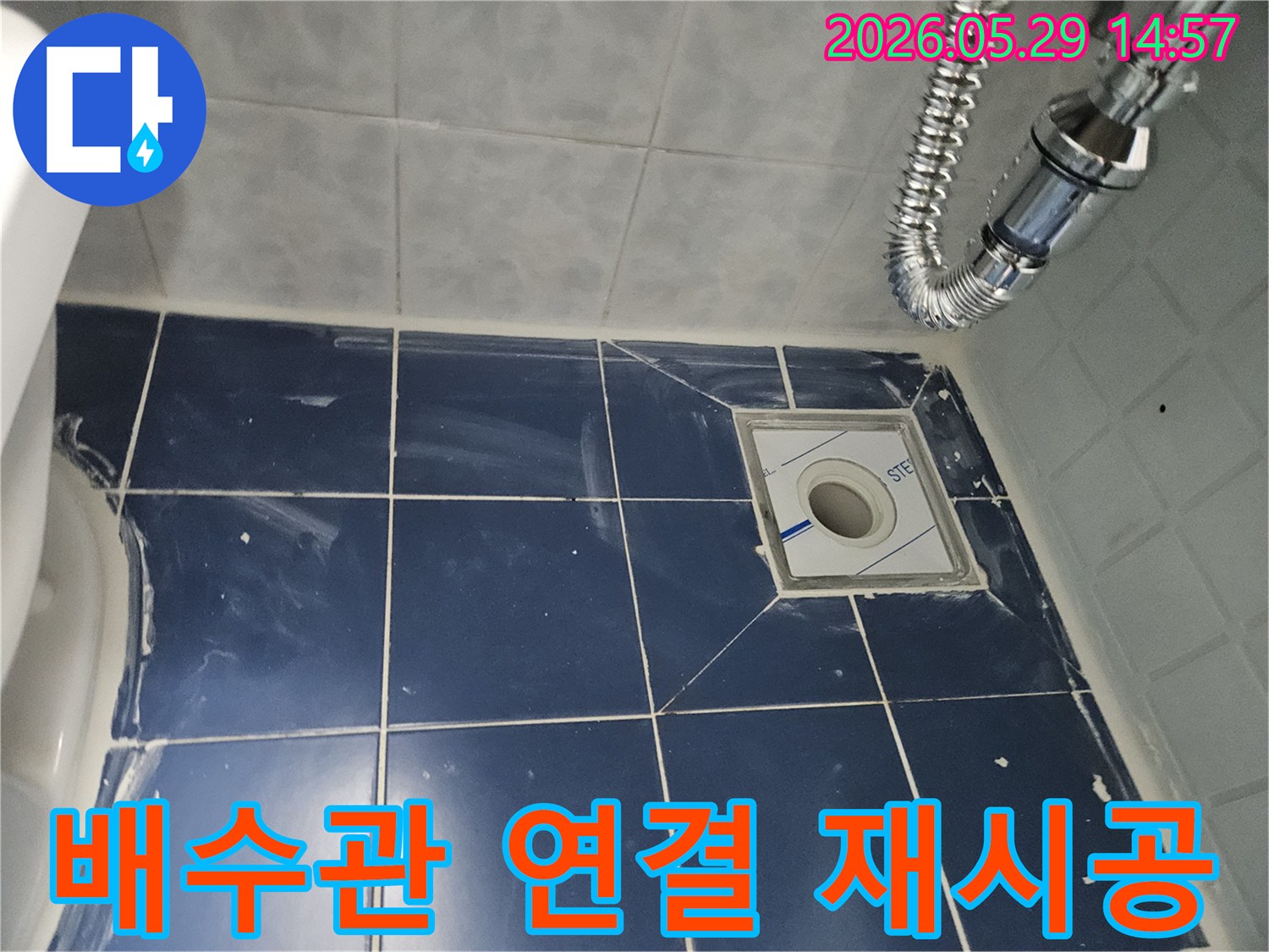 새로운 배수구와-주변 타일-그리고 견고하게-재시공된 유연한-배수관이-깔끔하게 설치된-욕실 바닥의-누수-공사-마무리-사진입니다