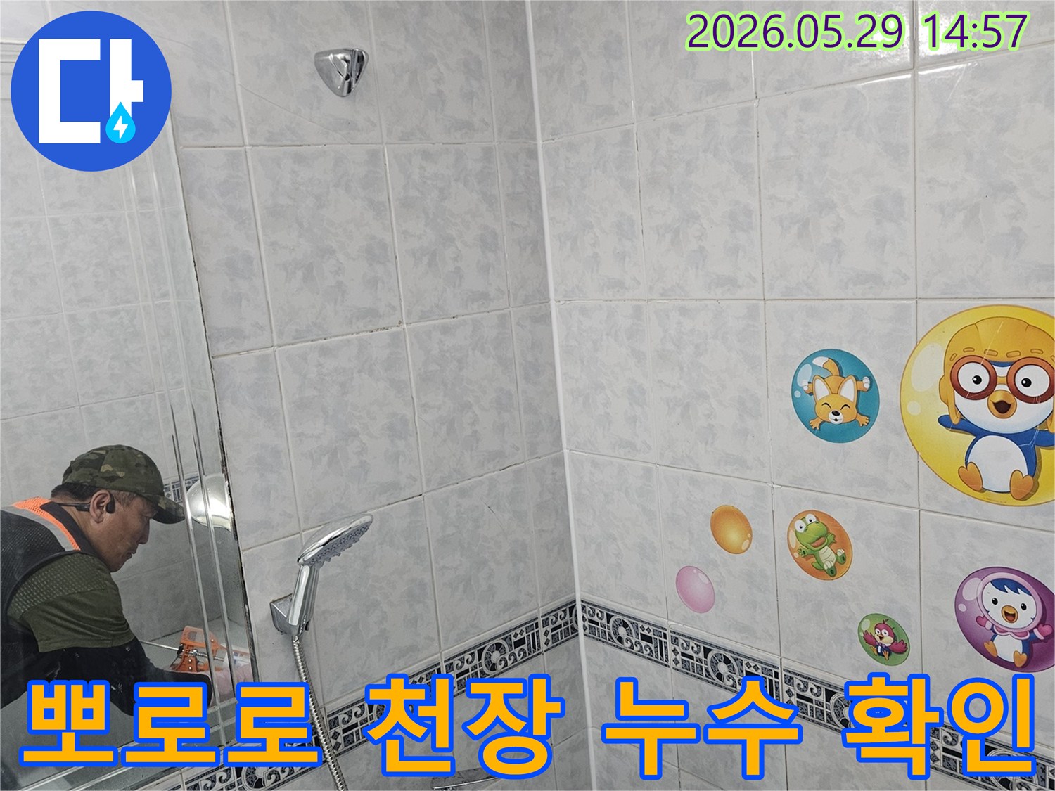 전문가가-동두천-생연주공아파트-욕실-천장의-뽀로로-스티커-아래-숨겨진-누수-문제를-꼼꼼히-살펴보는-모습입니다.
