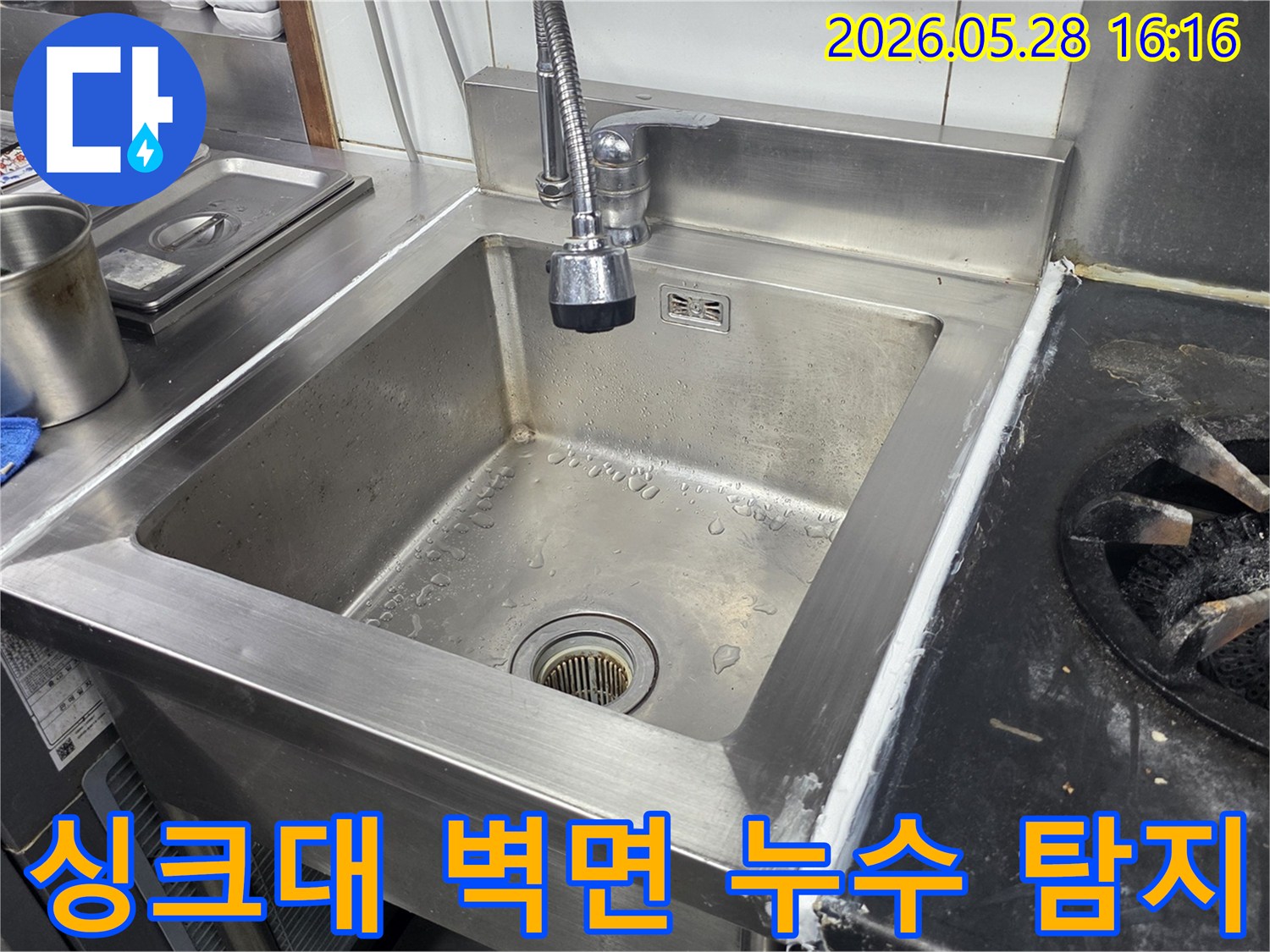 스테인리스-싱크대-뒤편-벽면에서-발생한-누수의-숨겨진-원인을-찾기-위해-전문-장비로-탐지하는-모습을-담은-사진