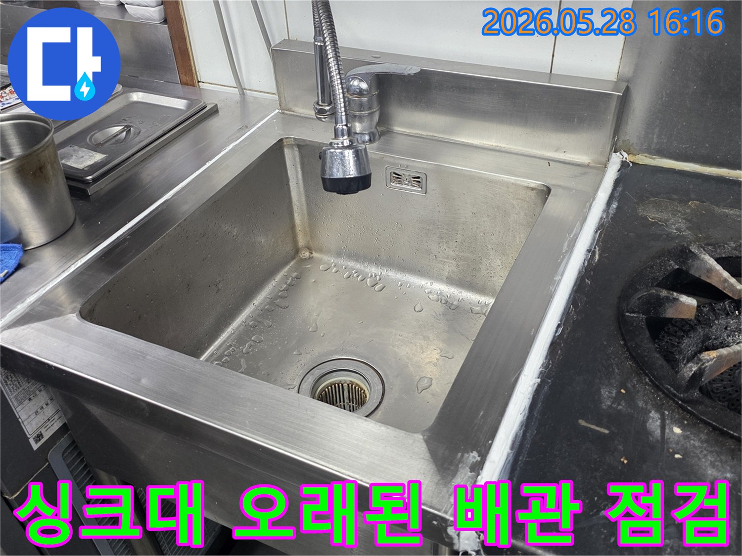 스테인리스-싱크대-하부의-오래된-배관을-전문-엔지니어가-면밀히-점검하고-필요시-교체하는-작업-현장을-보여주는-사진