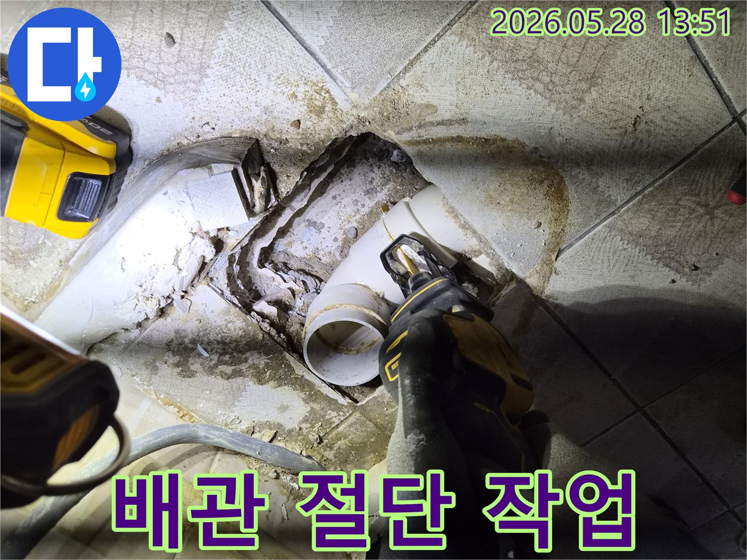 누수된 하수관을 교체하기 위해 전문가가 전동톱으로 배관을 절단하는-정확하고 신속한-배관 교체 작업 현장입니다.
