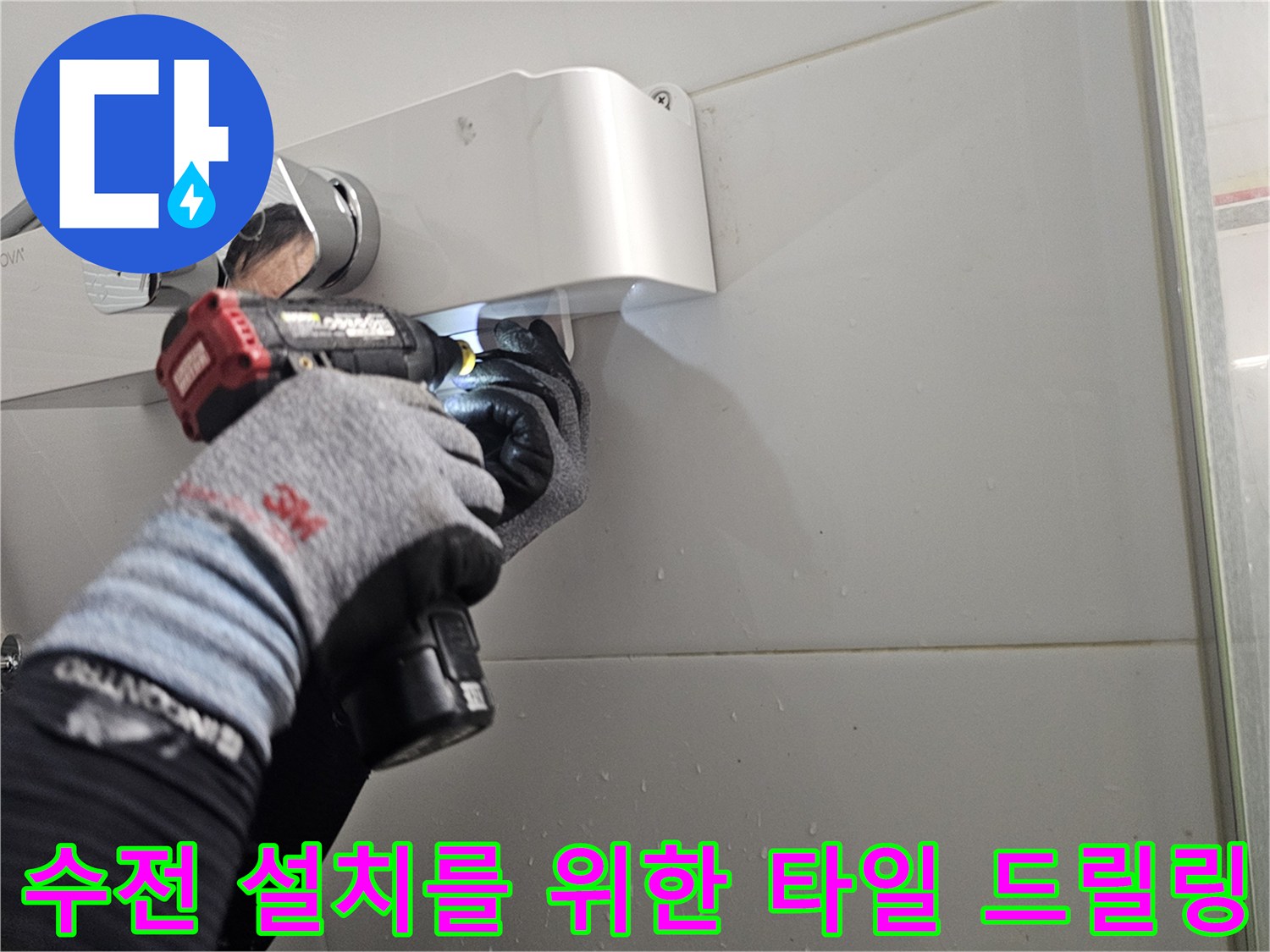 새로운 샤워기 거치대 고정을 위해-타일 벽면에 전동 드릴로 구멍을 뚫는 모습
