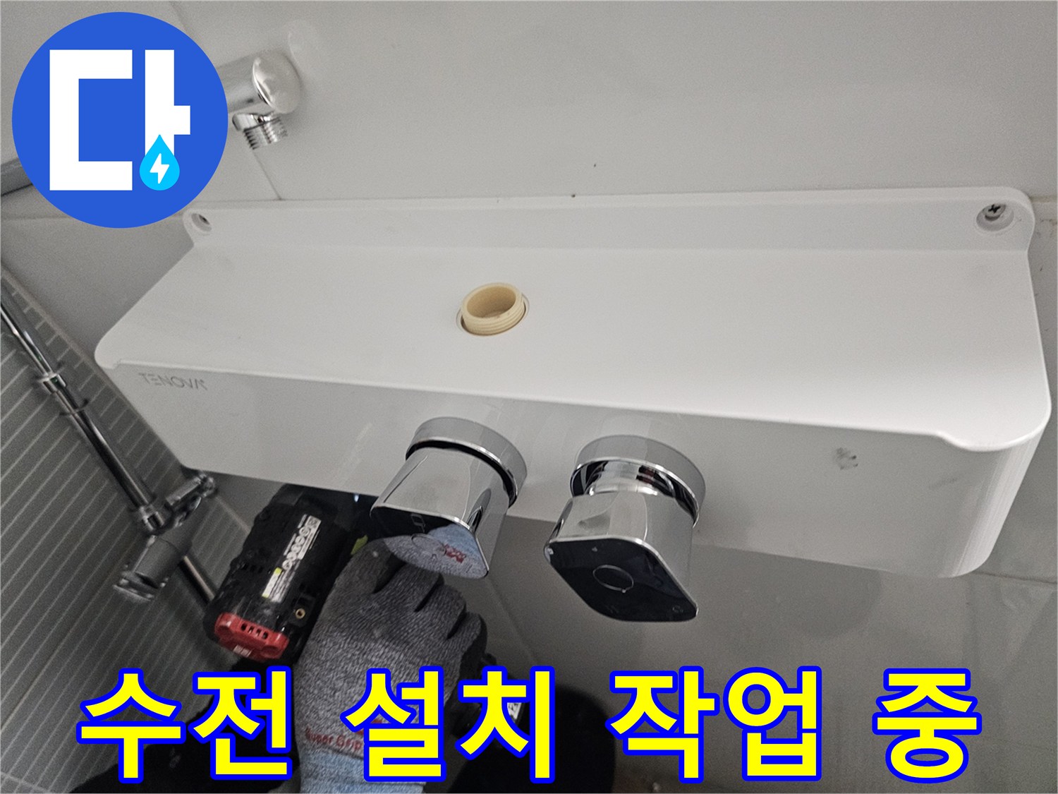 새로운 해바라기 수전을 벽면에 고정하기 위해 전동 드릴로 타일 작업을 진행하는 모습입니다