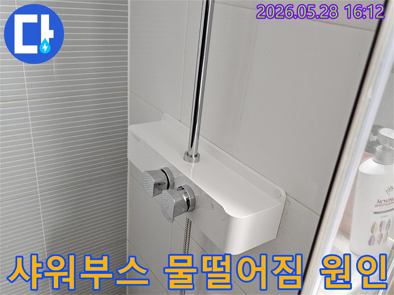 이 사진은-욕실 샤워부스-상단에 설치된-샤워기-수전과-벽면의-상태를-보여줍니다.