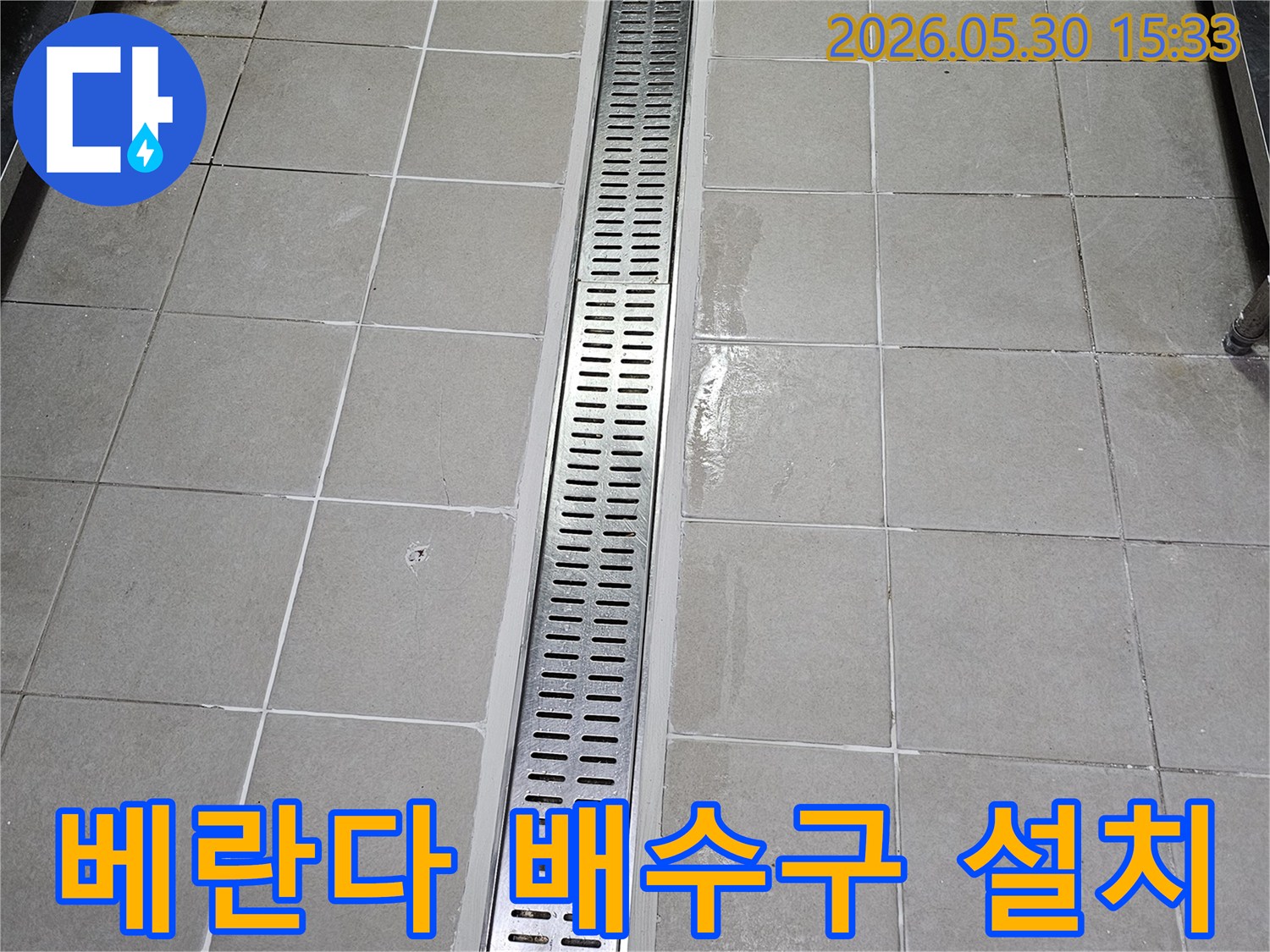 베란다 타일 벽면에-새롭게 설치된-스테인리스 선형 배수구-물이 고이지 않고-빠르게 배수되도록-시공된 모습
