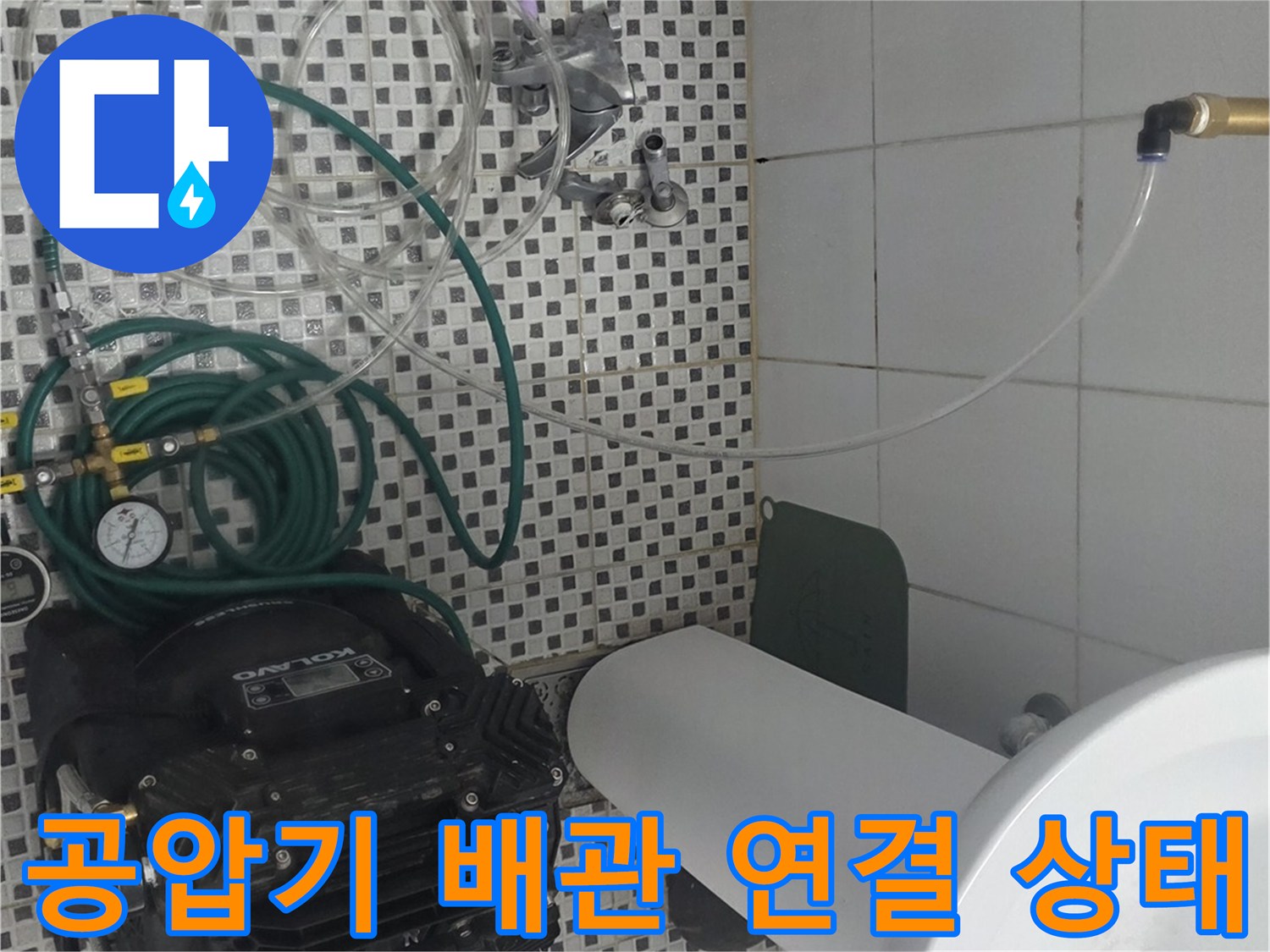세면대 아래 배관에 연결된 공압 테스트용 호스와 압력계