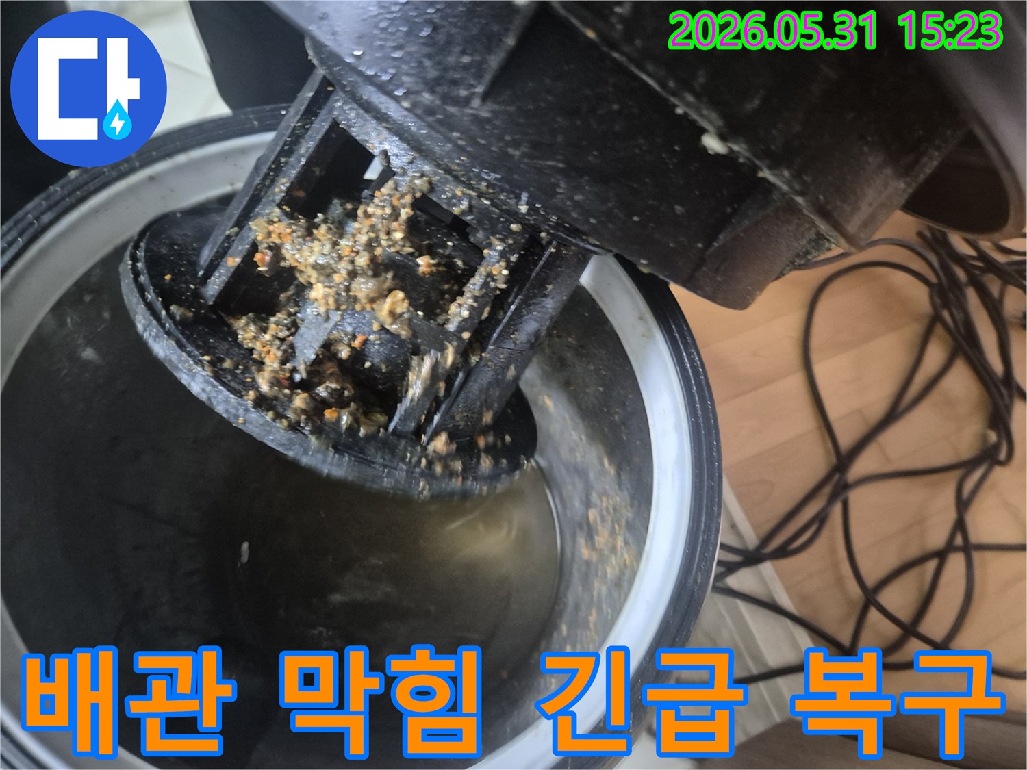 파주 청석마을 아파트에서-누수 엔지니어가-배관 막힘으로 인한 긴급 상황을-석션 장비로 이물질을 제거하며 복구하는 모습