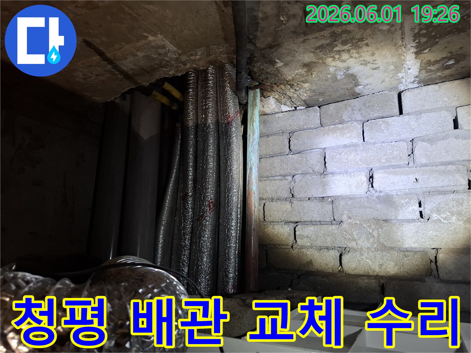 어두운 지하 공간에서-손상된 배관과-물에 젖은 벽돌 벽면이-보이는 누수 현장입니다