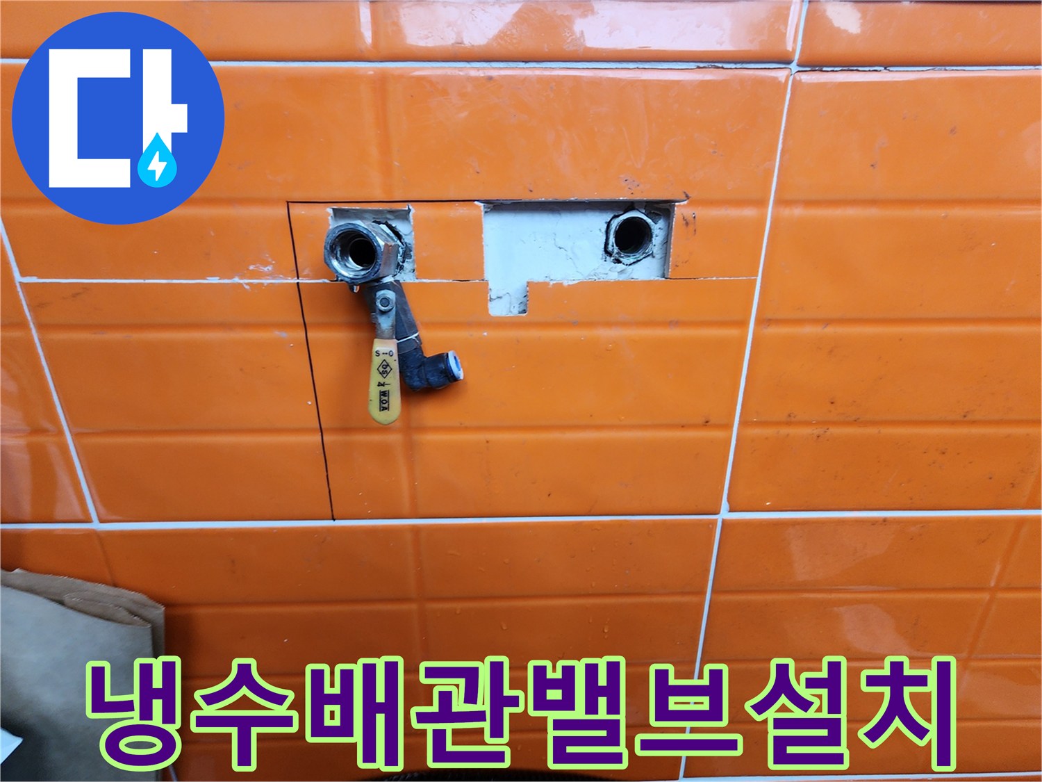 오렌지색-타일이-부분적으로-제거된-곳에-새로운-수도-밸브가-설치된-배관-수리-과정을-담은-사진입니다.