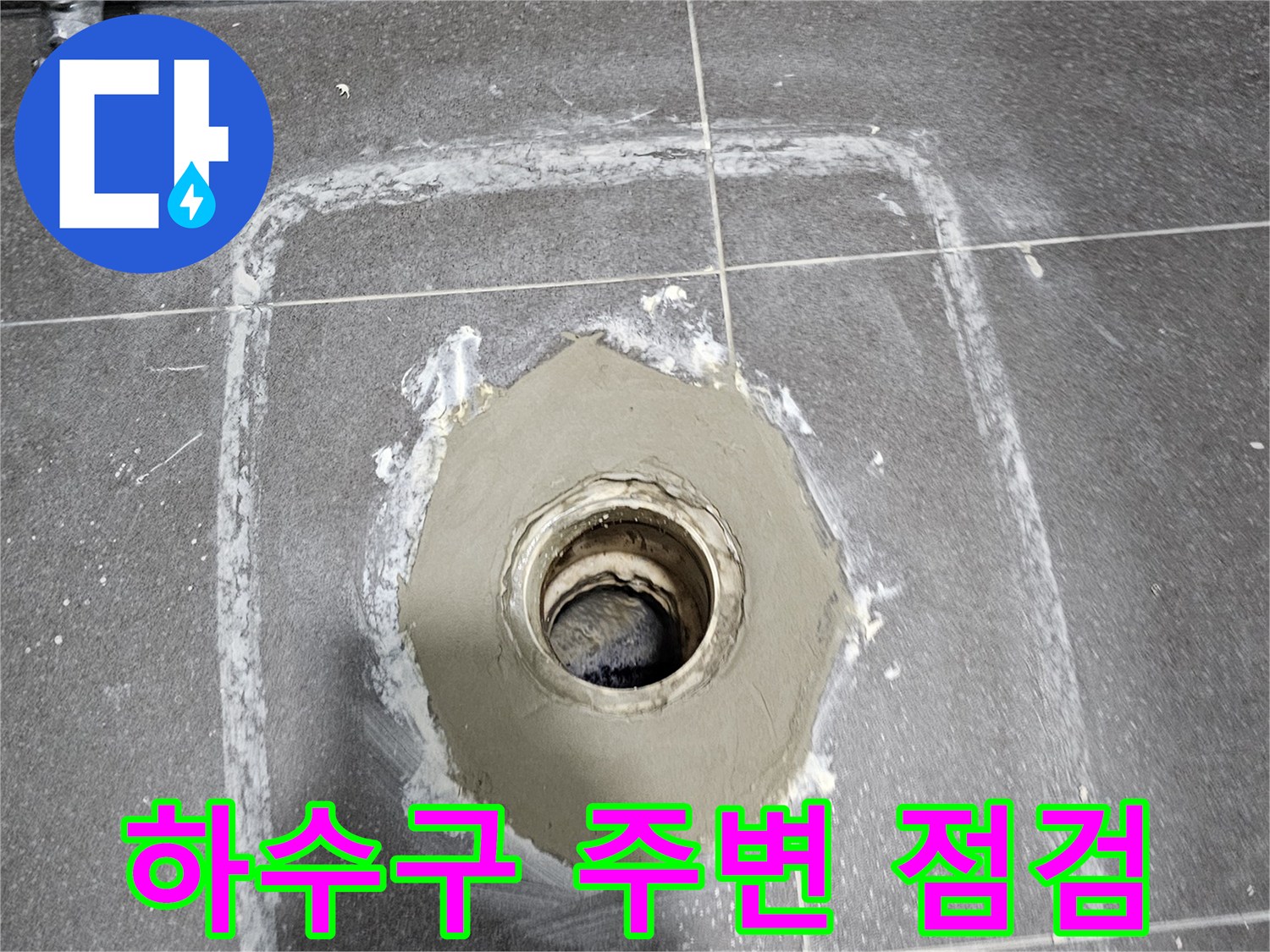 회색 타일 바닥 배수구 입구와 주변 마감재의 상태를 근접 촬영한 사진입니다.