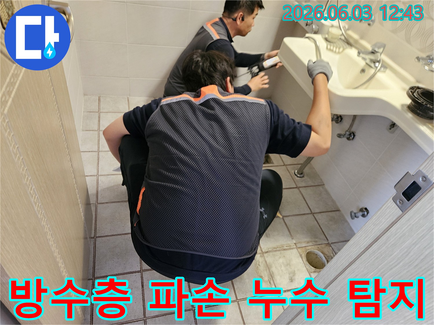 서울 중랑구 아파트 화장실에서-두 명의 누수 전문가가-바닥 방수층 파손 지점을-정밀하게 탐지하는 모습