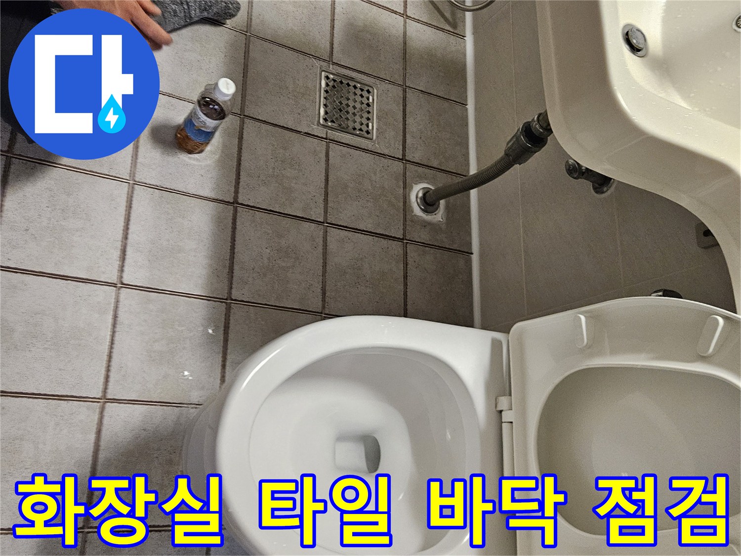 세면대 아래쪽 배수구와 변기 주변 타일 상태를 보여주는 사진입니다.