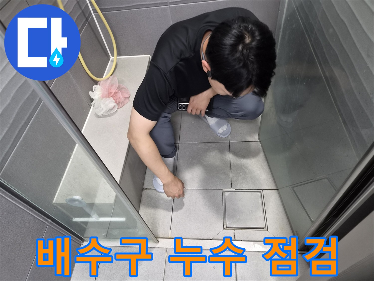천호동 아파트 샤워실에서-전문가가 배수구 주변의 누수 여부를-정밀하게 점검하는 모습