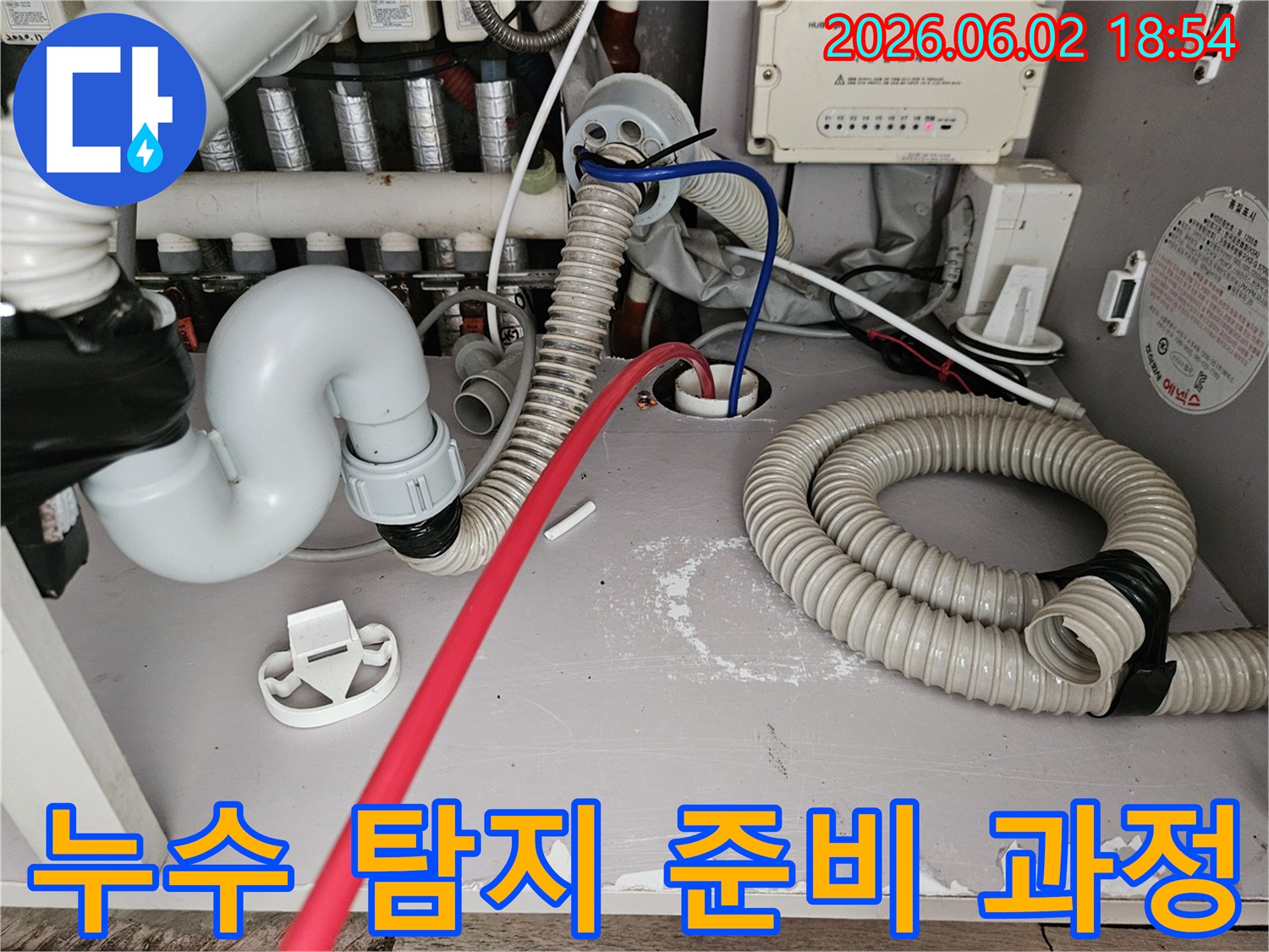 누수-탐지를-위해-보일러실-배관에-전문-장비를-연결하고-있는-작업-현장-사진