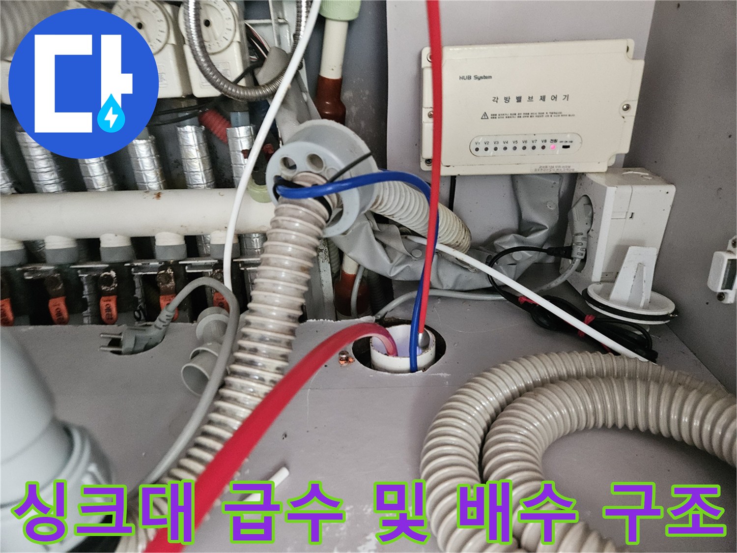 복잡하게 얽힌 싱크대 하부 배관과 수전 밸브 연결부