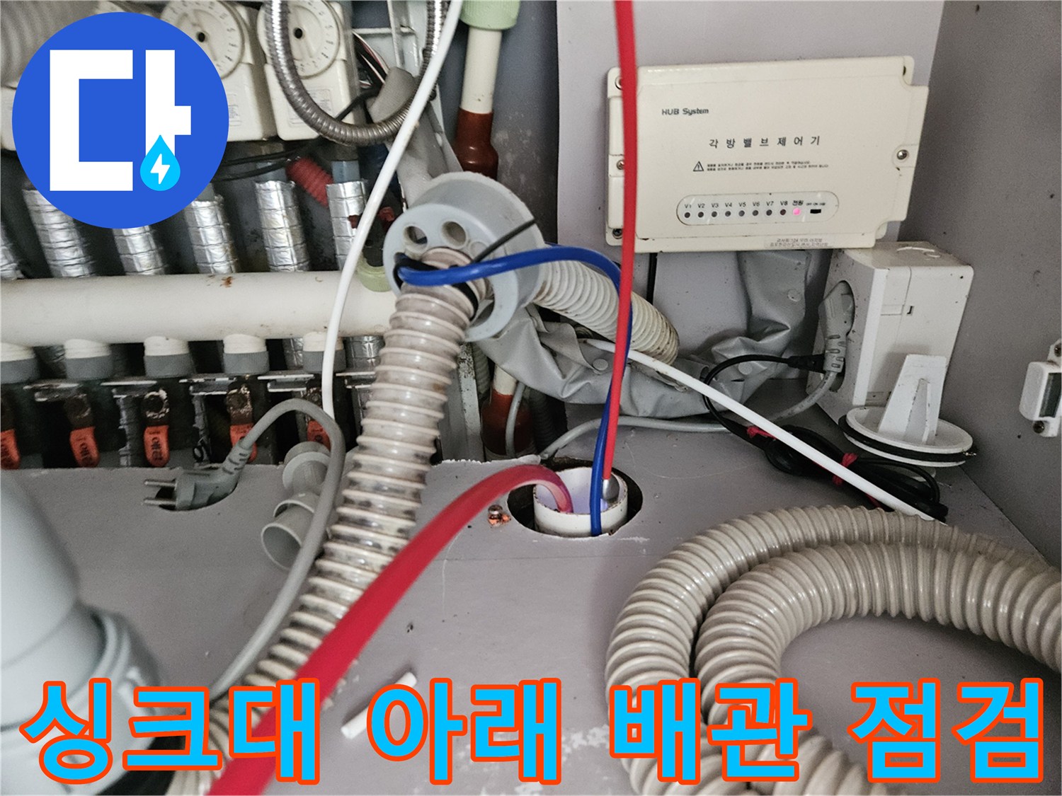 분배기와 싱크대 주름 호스가 연결된 싱크대 밑바닥 부위