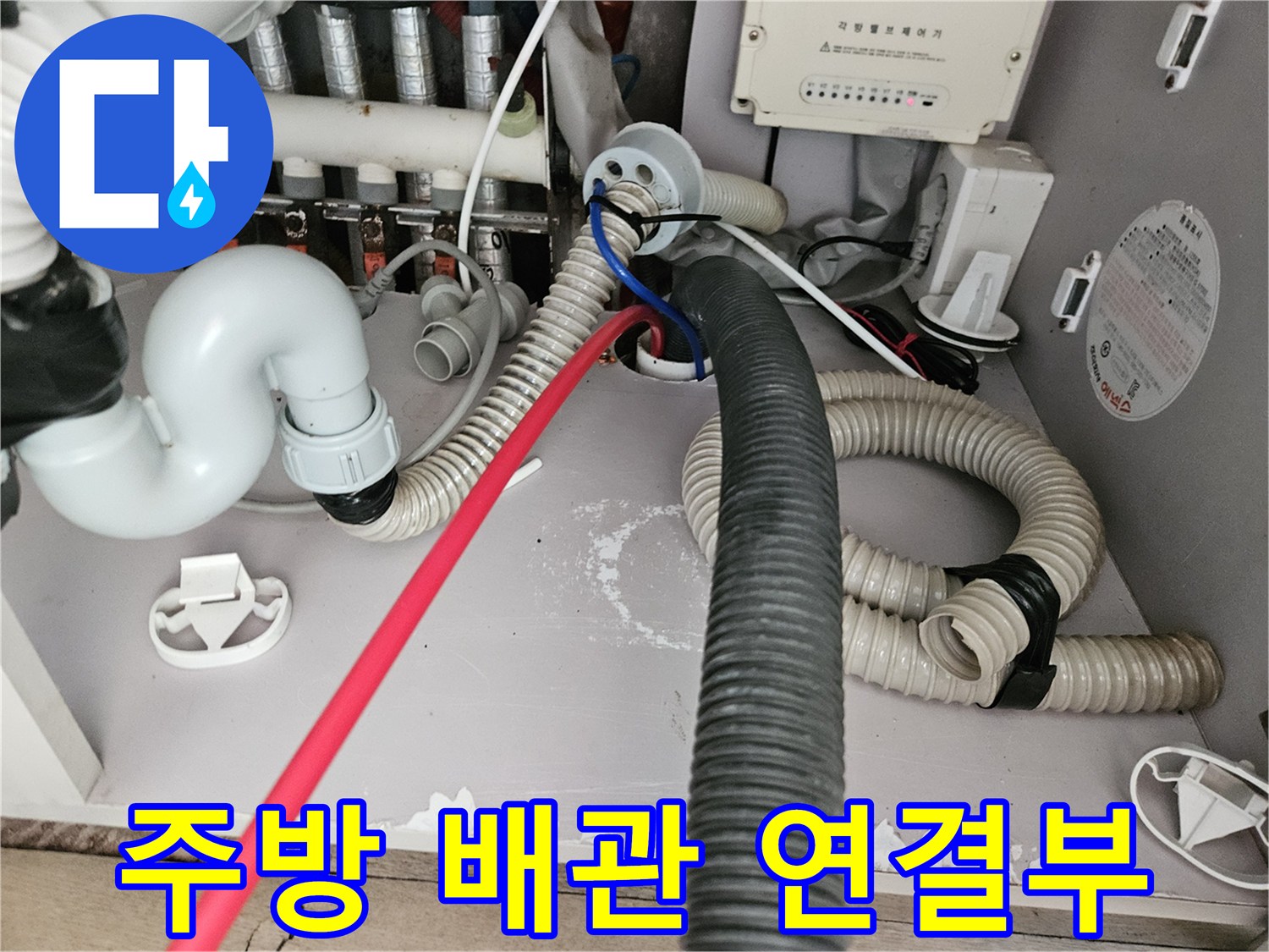 싱크대 아래쪽 굵은 주름관과 얇은 급수 배관의 교차 지점