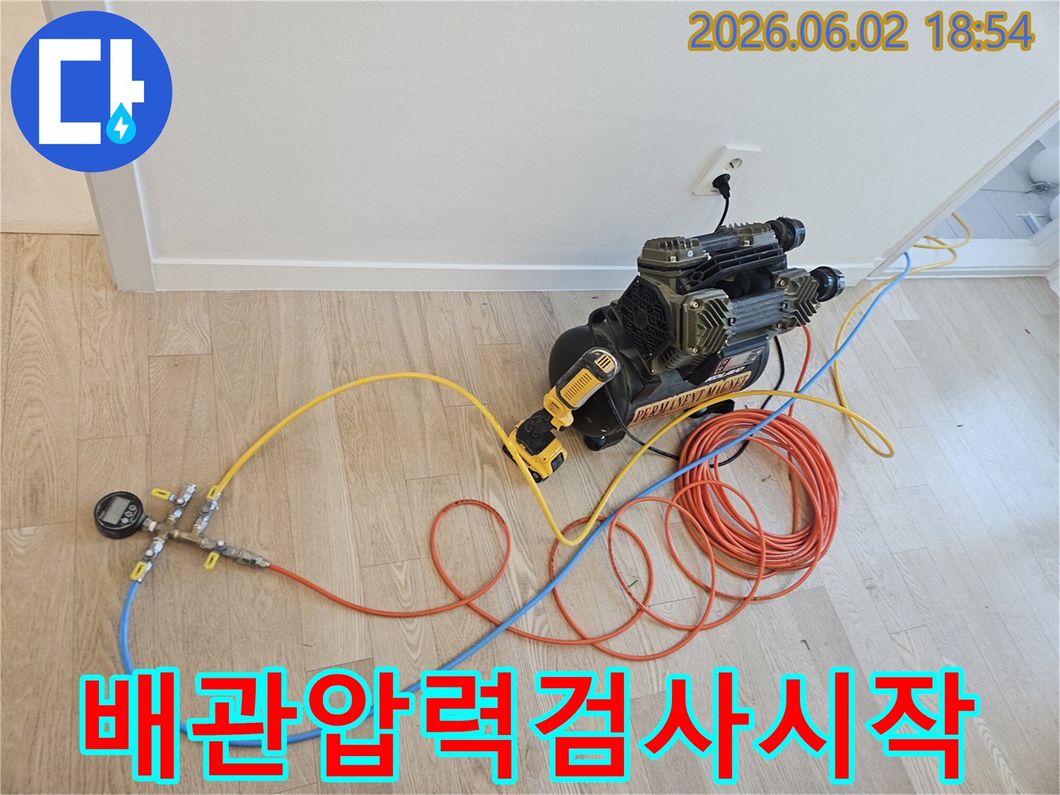 아파트 누수 해결을 위해 배관 압력 검사 장비가 연결되어 탐지 작업을 시작하는 모습