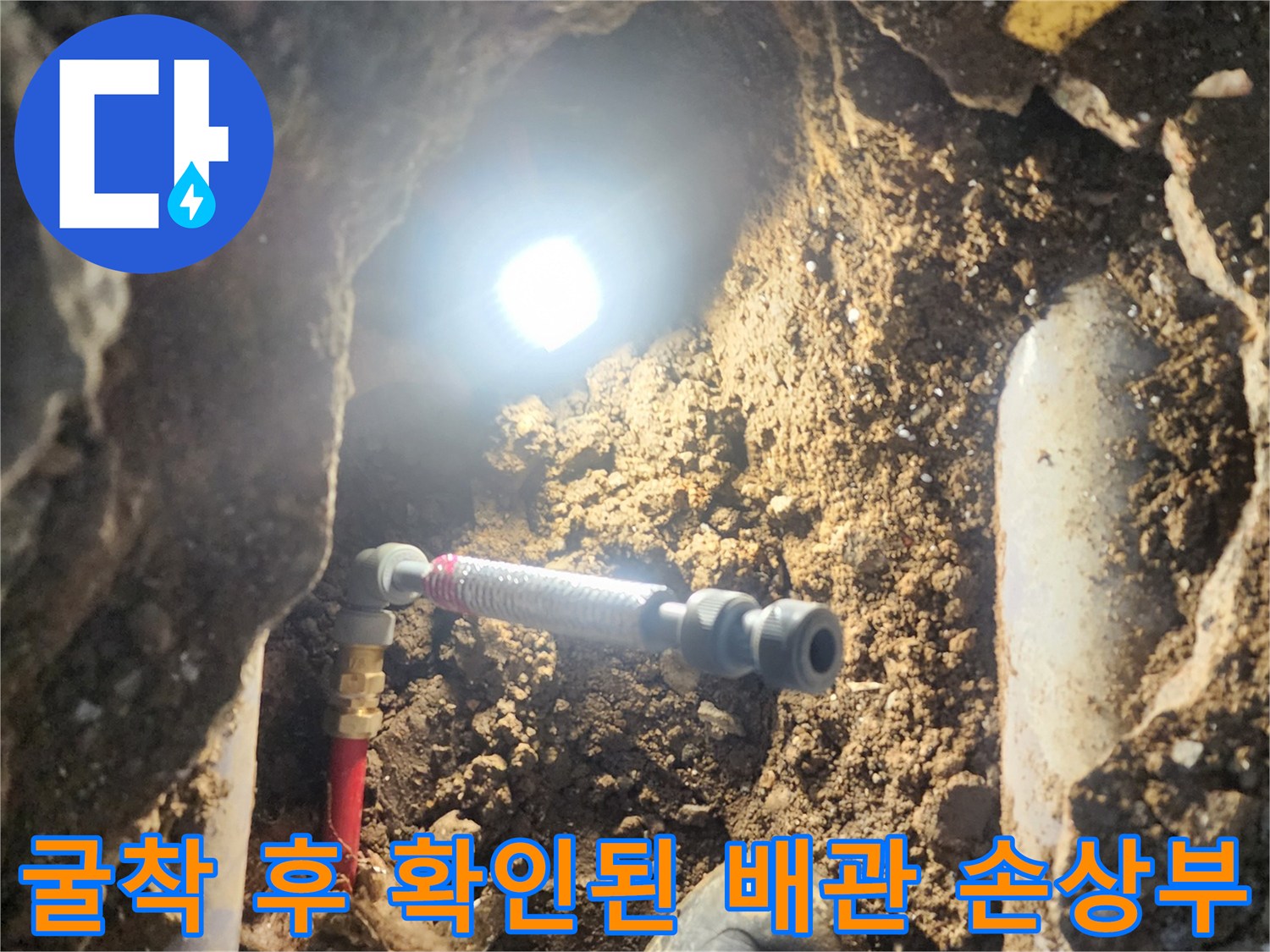 손상된 파이프 연결부와 주변 토양의 상태를 촬영한 사진