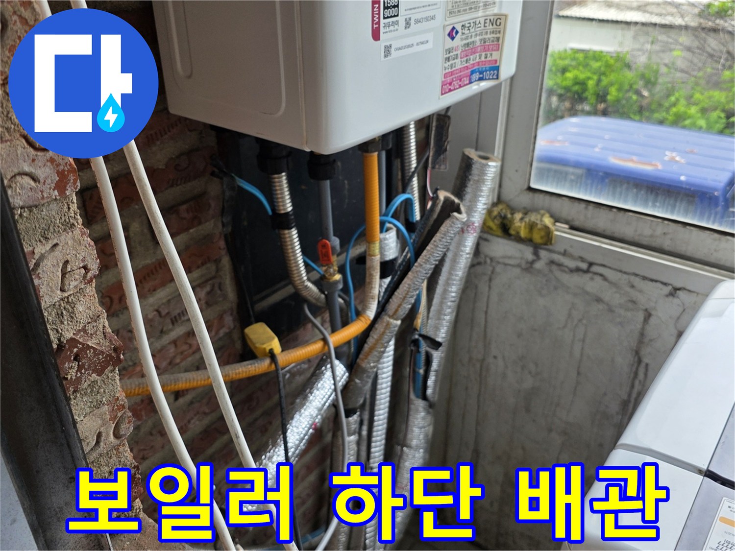 보일러실 내부의 노출된 배관과 연결 부속들을 근접 촬영한 사진입니다.
