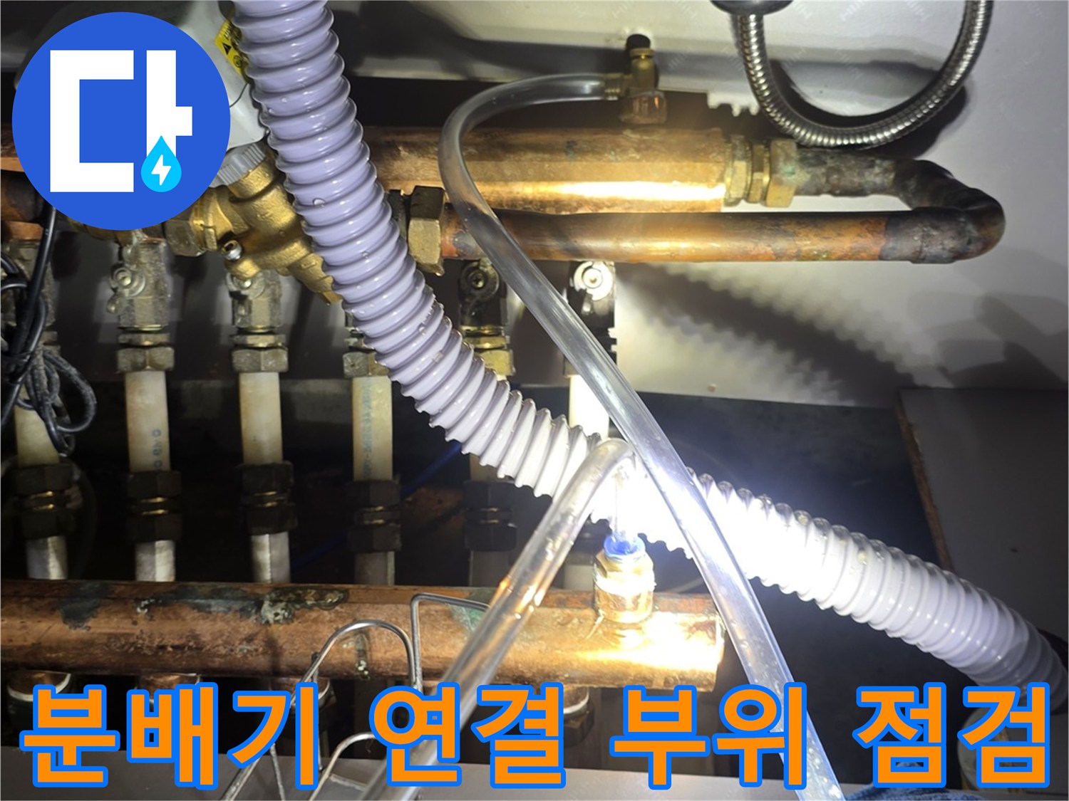 싱크대 하부장 내부에 복잡하게 얽힌 보일러 분배기 및 호스류