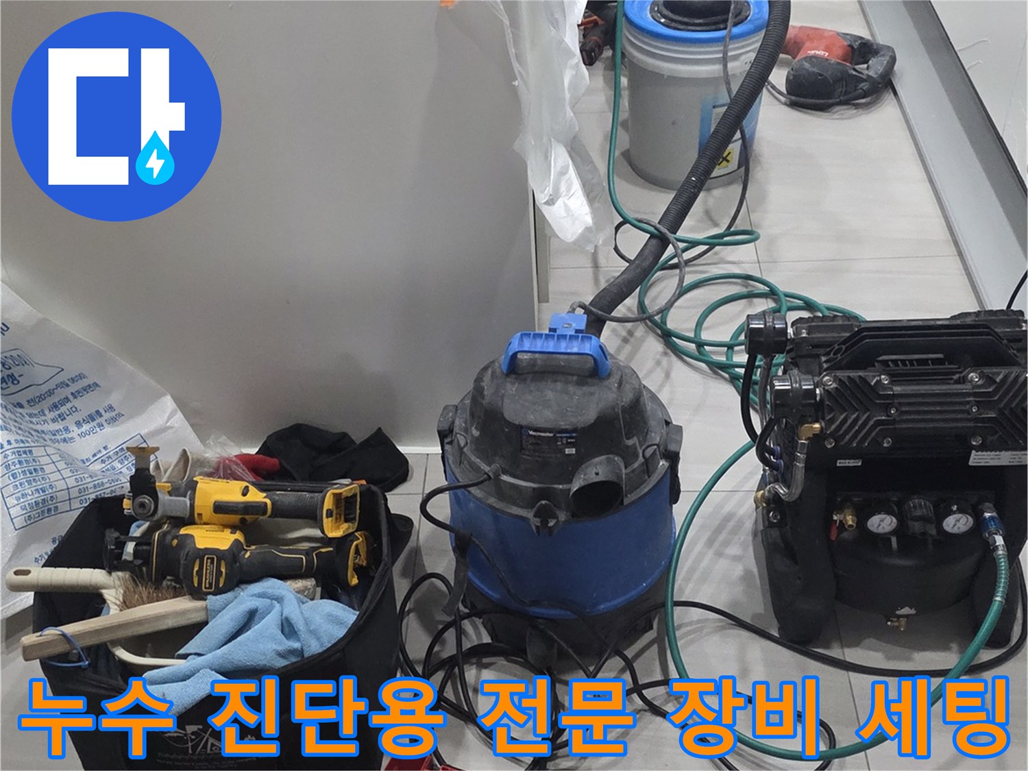 싱크대 하단 누수 확인을 위해 준비된-공압 테스트기 및 굴착용 전동 공구들