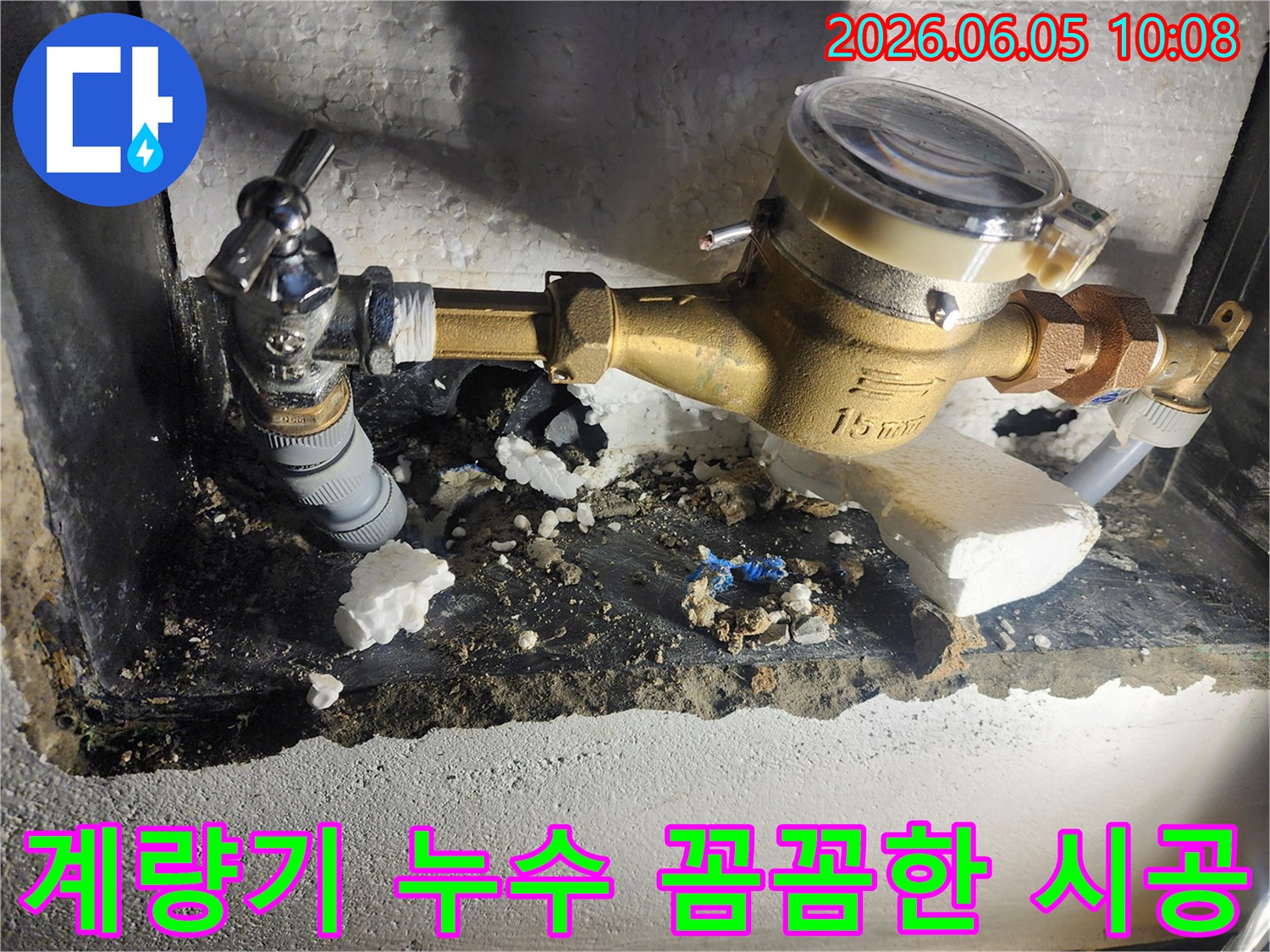 이 사진은 수도계량기 주변 누수 수리 현장에서-전문가가 직접 꼼꼼하게 배관을 연결하고-시공하는 모습을 보여줍니다-숙련된 기술-완벽한 수리