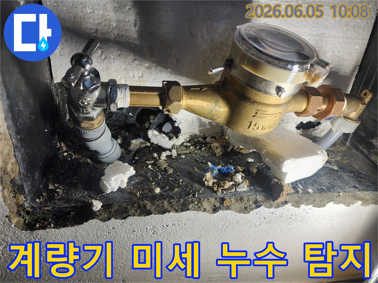 이 사진은 육안으로 확인하기 어려운 미세한 누수를 찾아내기 위해-수도계량기 주변을 정밀하게 탐지하는 현장을 보여줍니다-첨단 장비 활용-정확한 원인 파악