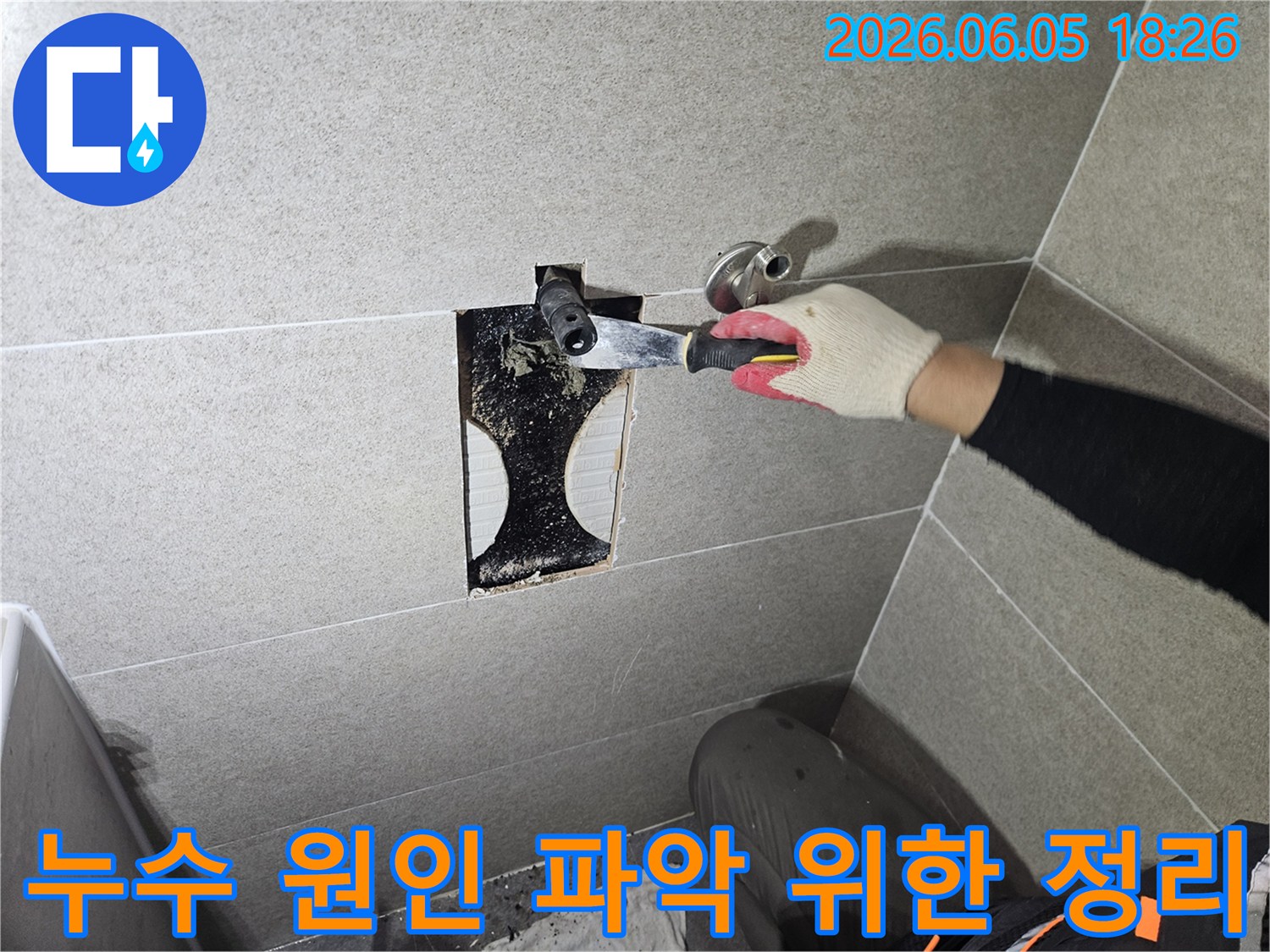 타일 안쪽에서 발견된-누수 흔적과-곰팡이를 제거하며-배관 상태를-면밀히 점검하는-전문가의 손길이-엿보이는 사진입니다.