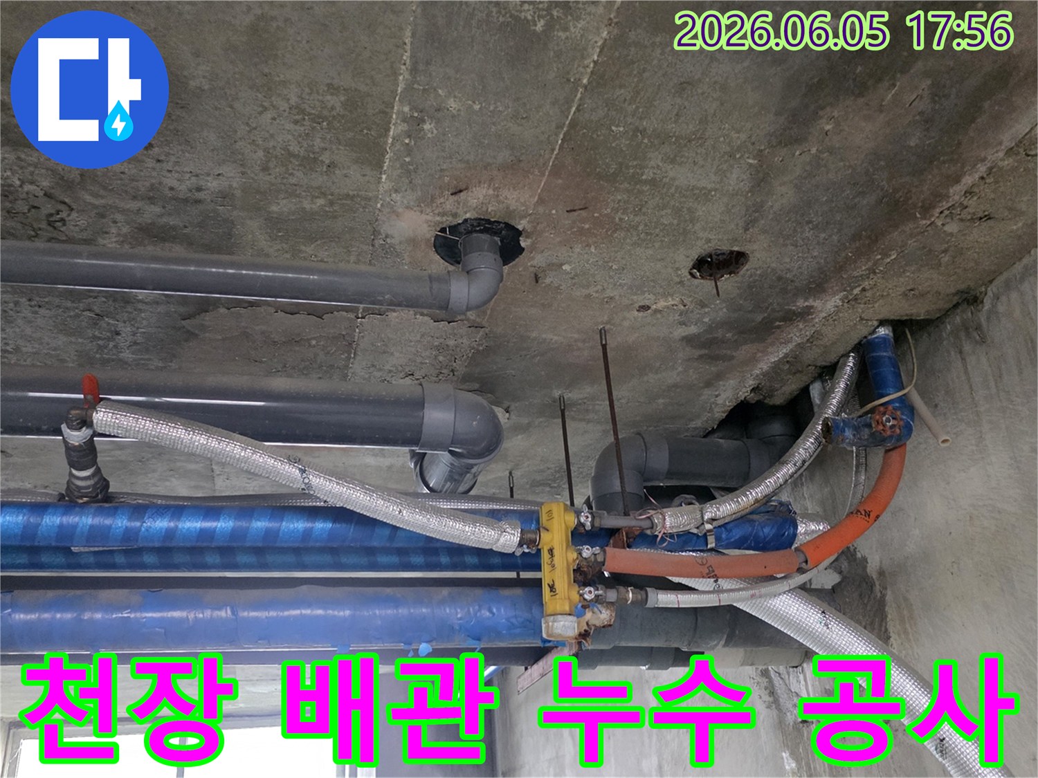 콘크리트-천장-아래-설치된-다양한-배관들의-복잡한-모습-누수-탐지-전문가가-현장을-면밀히-조사하고-있습니다